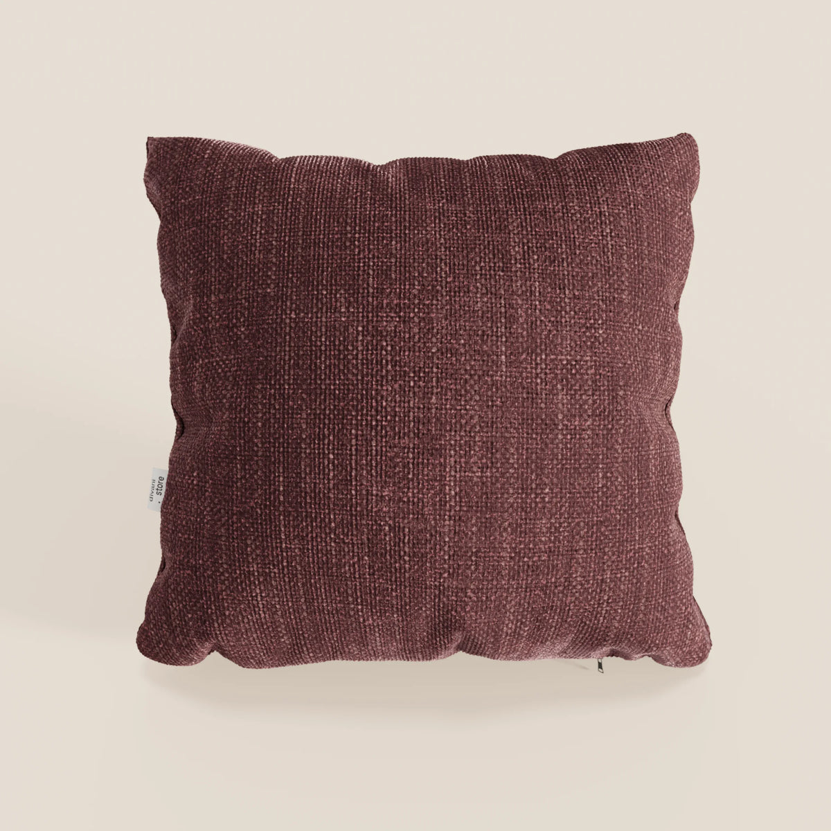Il cuscino Lyon di divitt.sbs, qui presentato nel colore T06 rosso, misura 45x45 cm ed è caratterizzato da un morbido tessuto impermeabile testurizzato con una piccola etichetta bianca sulla sinistra, su uno sfondo bianco sporco.