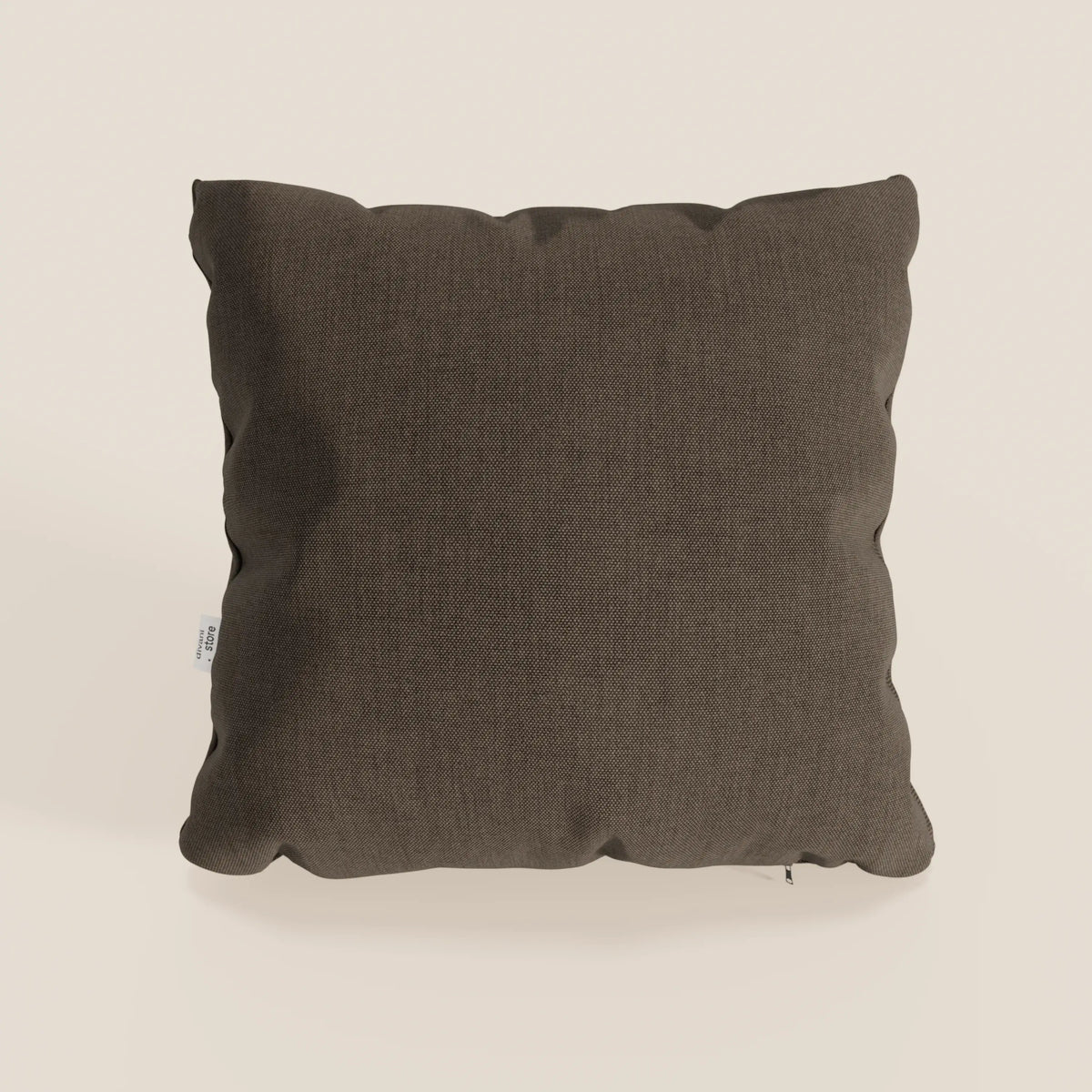 Un cuscino Honey 45x45 cm di divitt.sbs, quadrato e di colore marrone scuro, poggia su uno sfondo chiaro. Realizzato in tessuto impermeabile simil cotone T13 marrone, presenta angoli leggermente arrotondati, una texture sottile e una piccola etichetta bianca sulla cucitura sinistra.