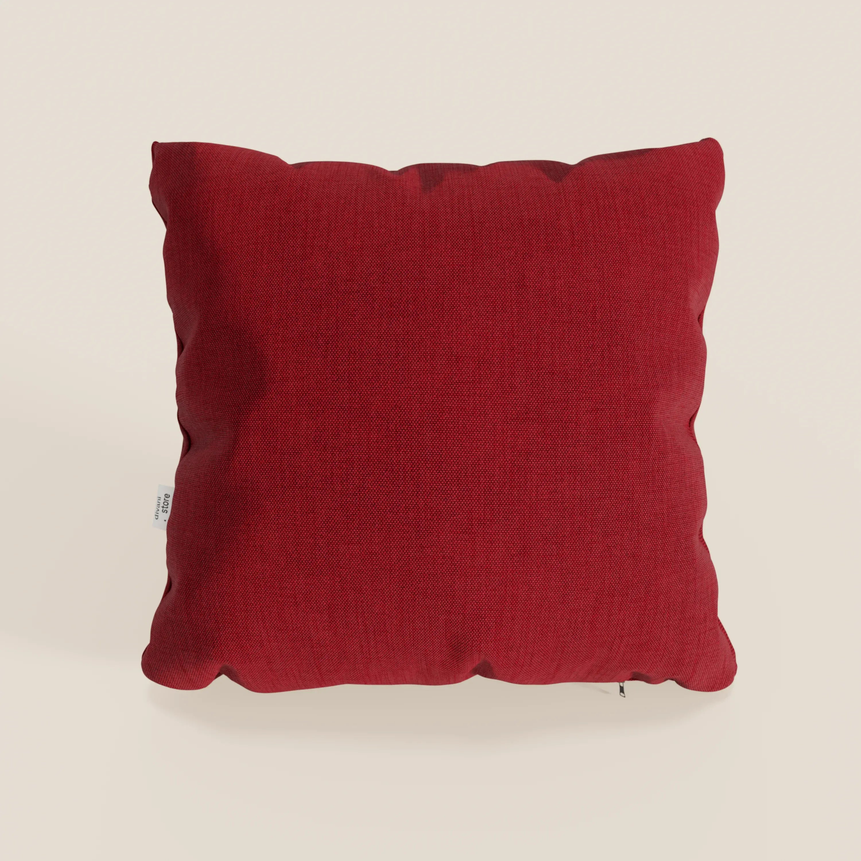 Il cuscino Honey di divitt.sbs, in tessuto simil cotone impermeabile T13 (45x45 cm) di colore rosso intenso, con rivestimento strutturato e targhetta in tessuto bianco, contrasta con uno sfondo chiaro. Adatto per uso interno o esterno.