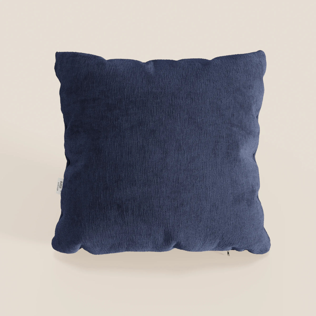Il cuscino Bolero di divitt.sbs, qui presentato in tessuto T31 blu scuro, è caratterizzato da un disegno quadrato morbido, felpato e strutturato con una piccola etichetta bianca e poggia su uno sfondo bianco sporco. Il cuscino è smacchiabile, impermeabile e irrestringibile.