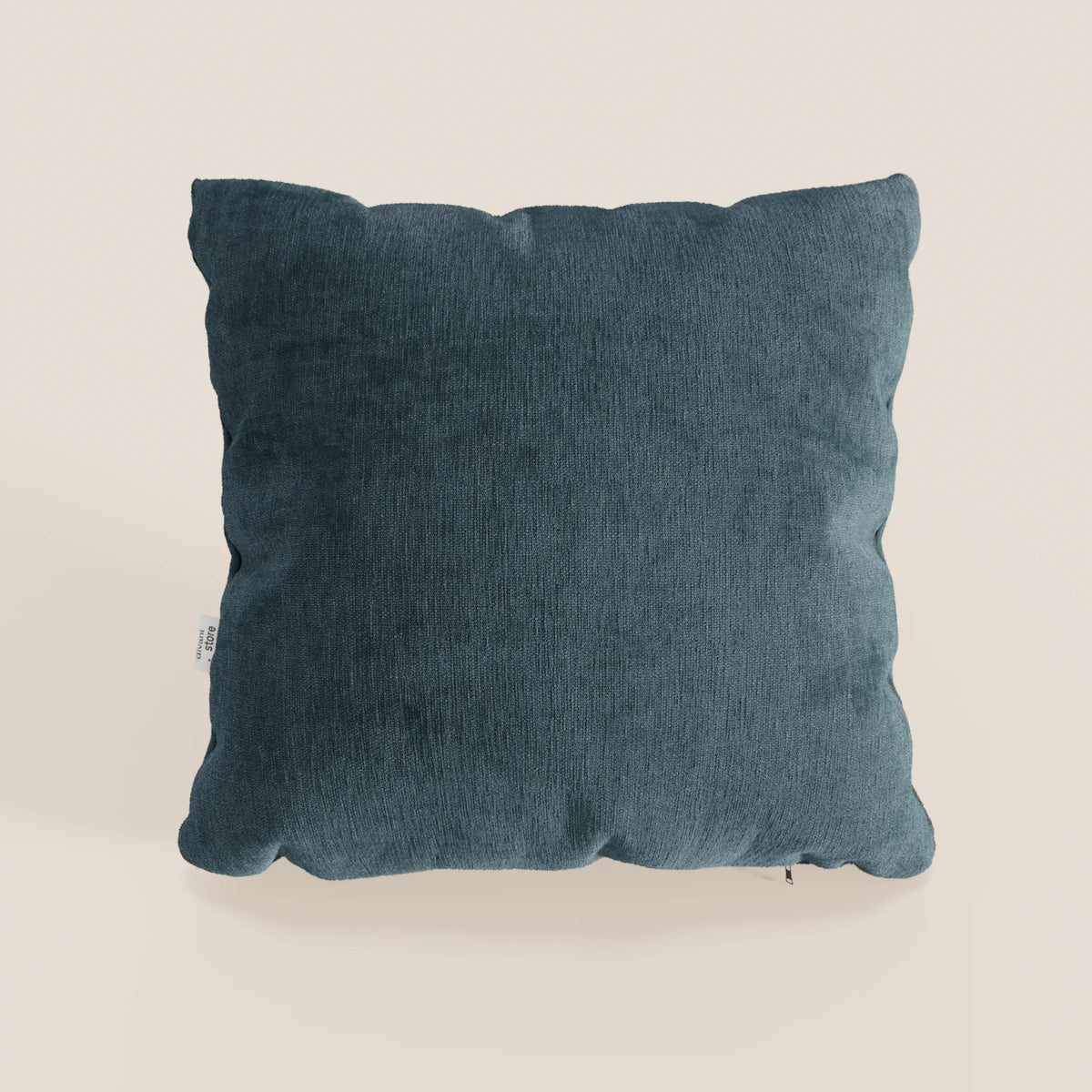 Il cuscino Bolero di divitt.sbs, di colore blu scuro, è di forma quadrata con angoli leggermente arrotondati, una finitura strutturata e una piccola etichetta bianca. Realizzato in morbido tessuto T31 antimacchia, impermeabile e non restringente.