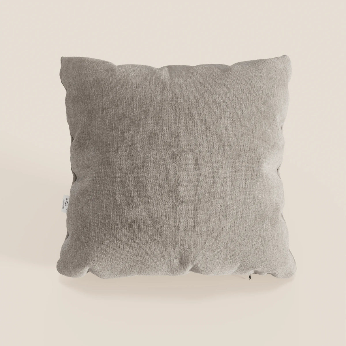 Il cuscino Bolero di divitt.sbs è di colore grigio chiaro, con forma quadrata, bordi arrotondati, cuciture a vista e una piccola etichetta bianca. Realizzato in morbido tessuto T31, resistente alle macchie, impermeabile e non restringente.