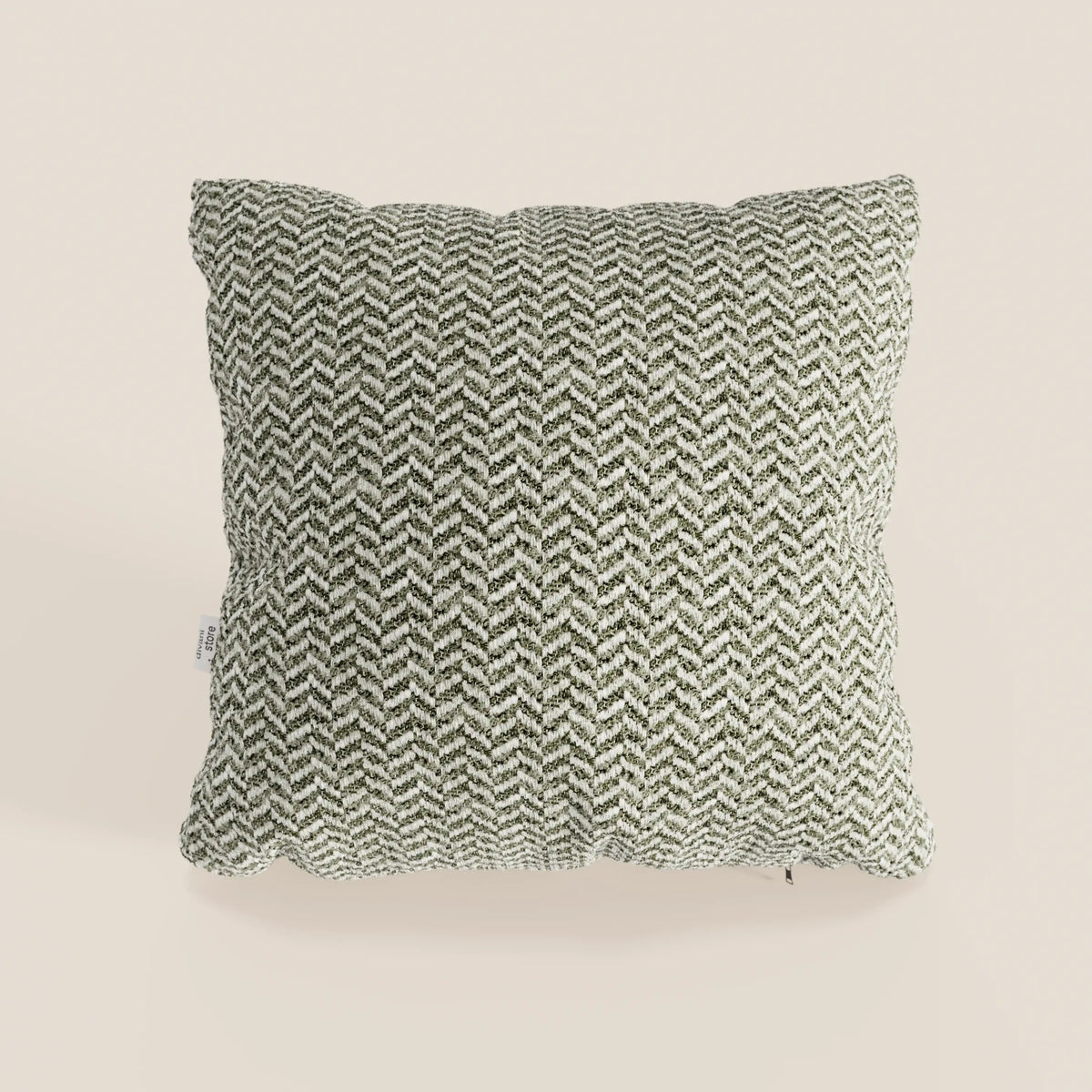 Il cuscino Sorrento 45x45 in lino di divitt.sbs presenta un motivo a spina di pesce bianco e nero su un morbido tessuto di lino dalla trama ruvida. Come tutti i cuscini lavabili in lavatrice, è elegante e di facile manutenzione. Nell’immagine è raffigurato su uno sfondo beige chiaro a tinta unita, fotografato dall’alto.