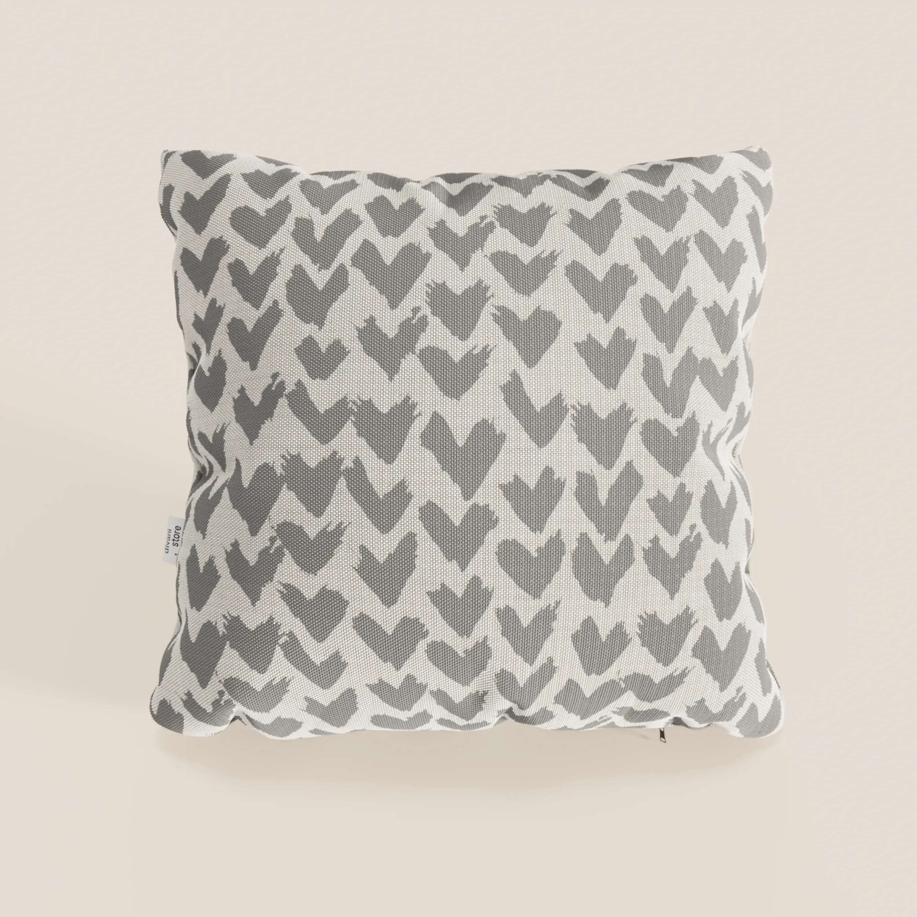 Il cuscino geometrico Arrow di divitt.sbs è un cuscino decorativo in tessuto grigio idrorepellente, caratterizzato da un motivo geometrico e da un'etichetta in tessuto sul lato, su uno sfondo chiaro e neutro. Disponibile in più colori.