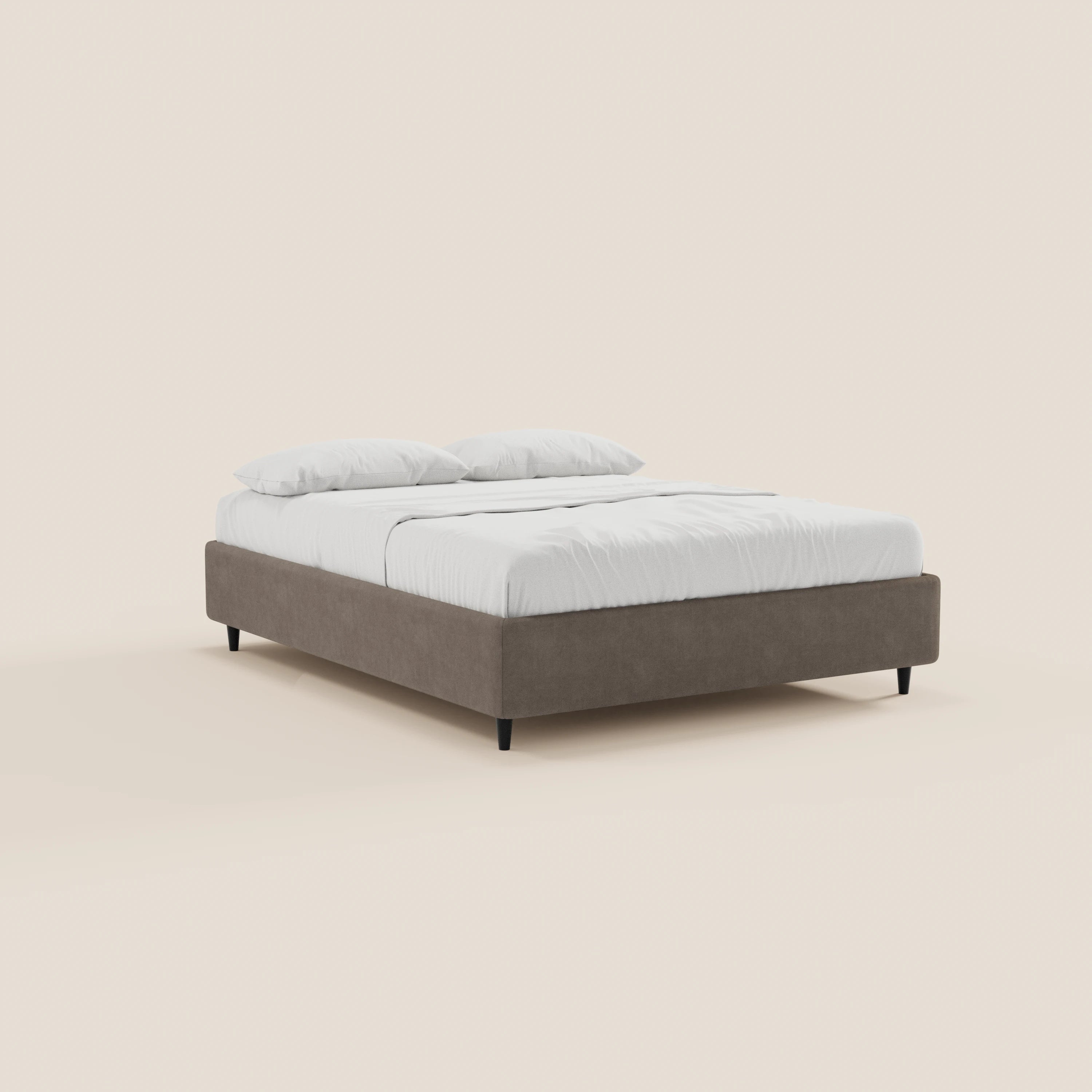 Il letto sommier imbottito con contenitore ERON di Letti.store presenta una struttura in tessuto impermeabile beige certificato Oeko-Tex su gambe nere, abbinato a biancheria da letto e cuscini bianchi su uno sfondo beige chiaro.