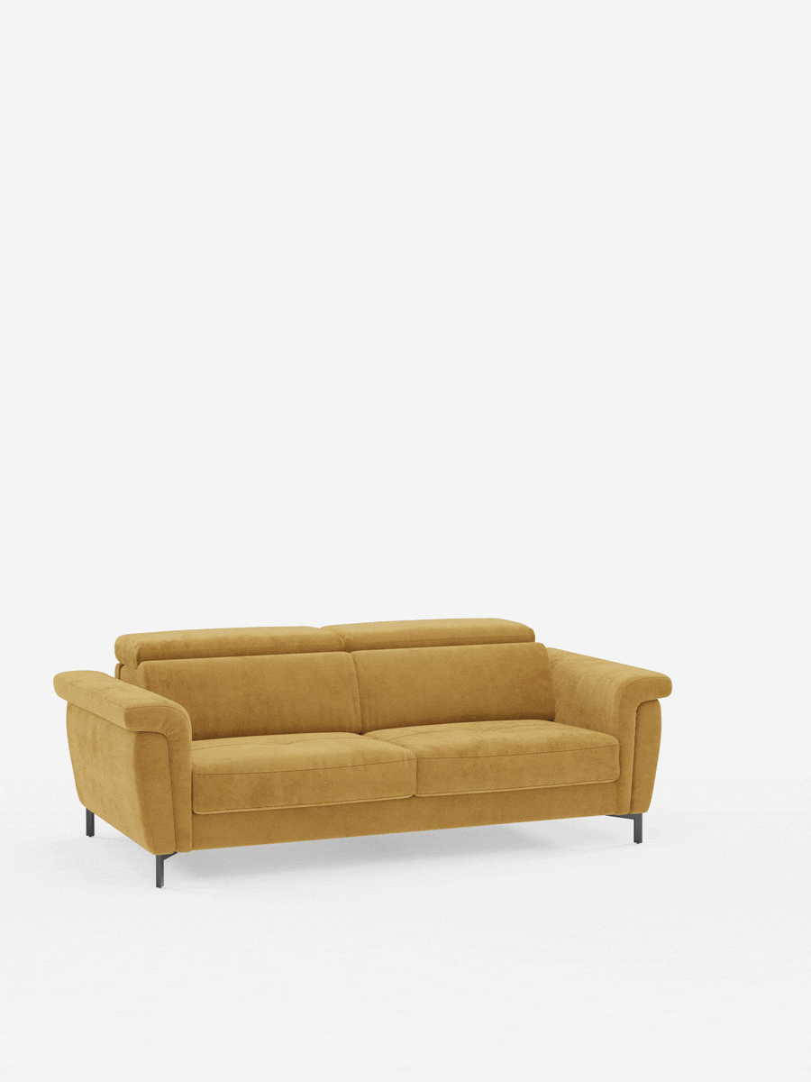 Un moderno divano a due posti color giallo senape, con morbidi cuscini, braccioli arrotondati e sottili gambe nere, è posizionato al centro di uno sfondo bianco a tinta unita. Il divano letto di design Capri con piedini alti di divitt.sbs è sapientemente realizzato in manifattura italiana e rivestito in un raffinato tessuto effetto velluto smacchiabile T30, resistente alle macchie. Questo divano letto è dotato di poggiatesta regolabili, schienale basso e un design semplice e contemporaneo.