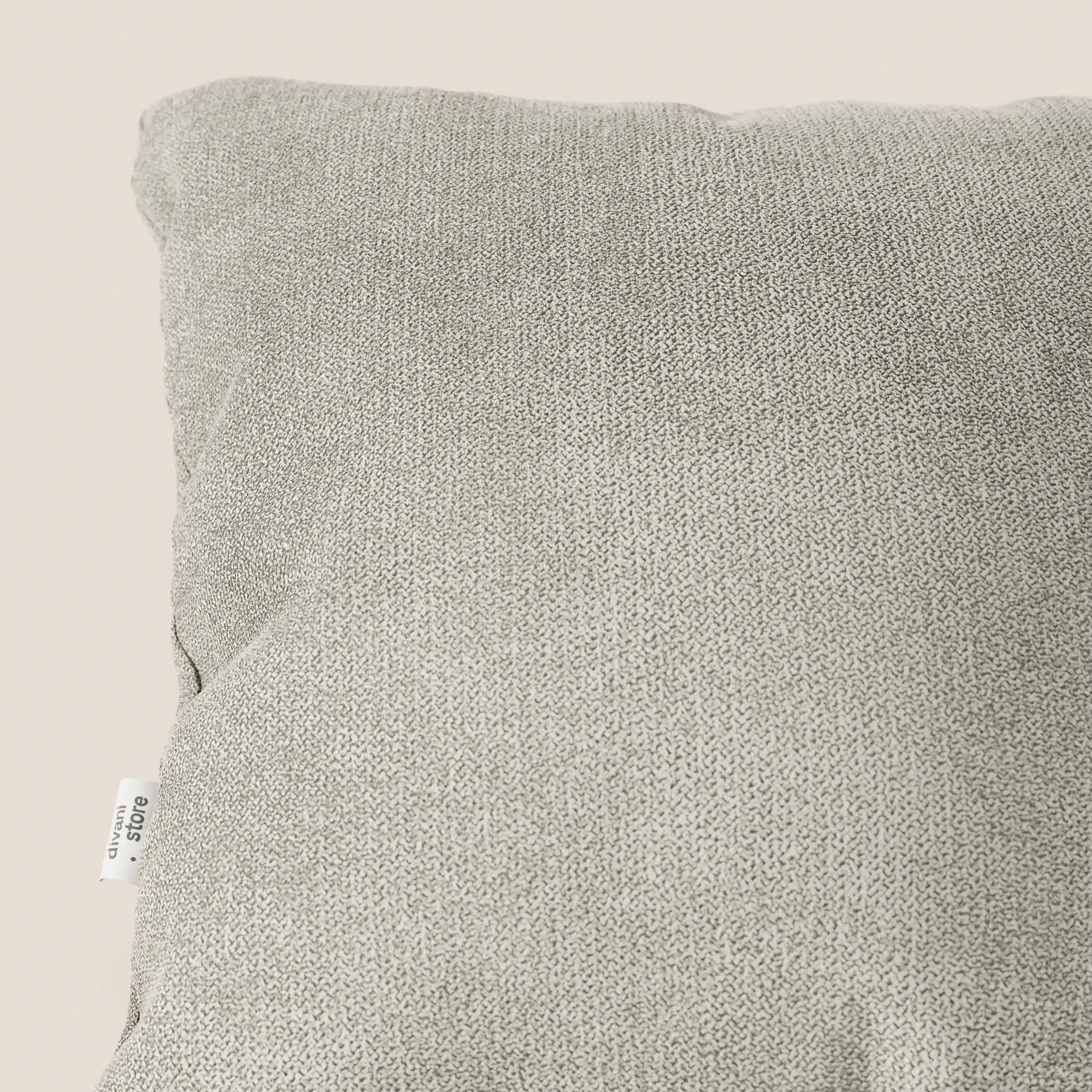 Primo piano del cuscino Destiny di divitt.sbs in tessuto morbido impermeabile T02 panna, che mostra la sua superficie morbida e strutturata e la targhetta bianca su sfondo beige. Di facile manutenzione con fodera lavabile; disponibile in diversi colori.