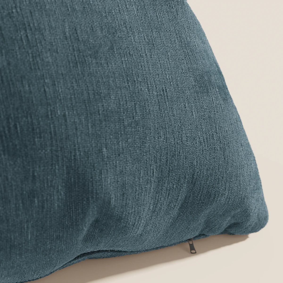 Primo piano di Bolero cuscino di divitt.sbs in blu, con tessuto T31 morbido e testurizzato, resistente alle macchie, impermeabile e non restringente. Una piccola cerniera vicino al bordo inferiore aggiunge un dettaglio sullo sfondo chiaro.