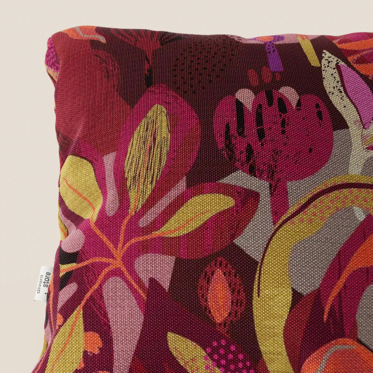 Primo piano del cuscino Joy collezione 45x45 cm di divitt.sbs, caratterizzato da una vivace fantasia floreale multicolore sul rosso, in fresco cotone impermeabile. Elegante e pratico, è di facile manutenzione tra i cuscini lavabili in lavatrice.