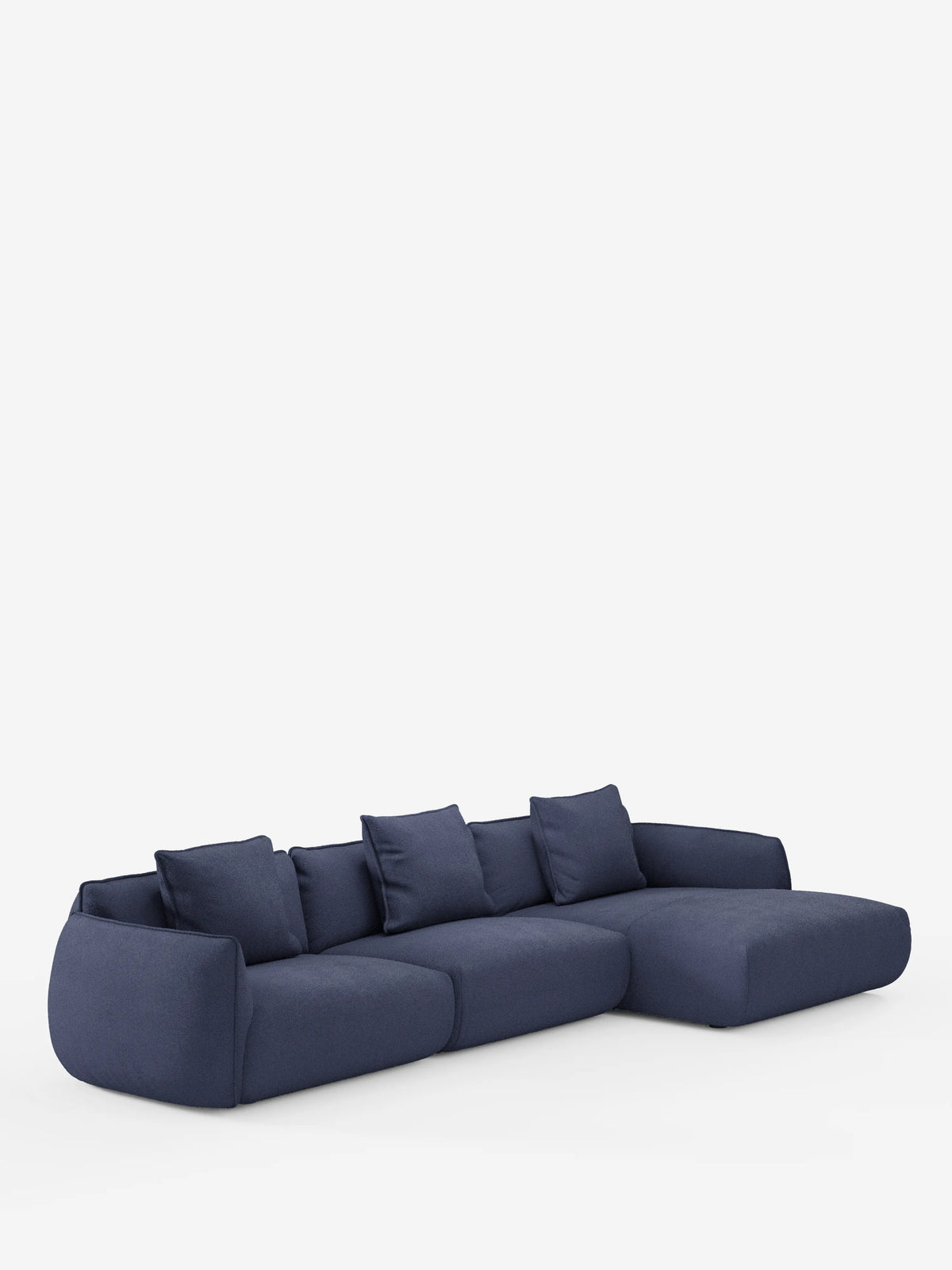 Un moderno divano angolare Nimbus con penisola componibile in morbido tessuto effetto cotone lavabile T33 di divitt.sbs, caratterizzato da un intenso colore blu navy con tre cuscini di seduta, cinque cuscini dello schienale abbinati e una chaise longue allungata sulla destra. Su uno sfondo bianco a tinta unita, questo design minimalista si caratterizza per i bordi morbidi e arrotondati e l'imbottitura soffice.