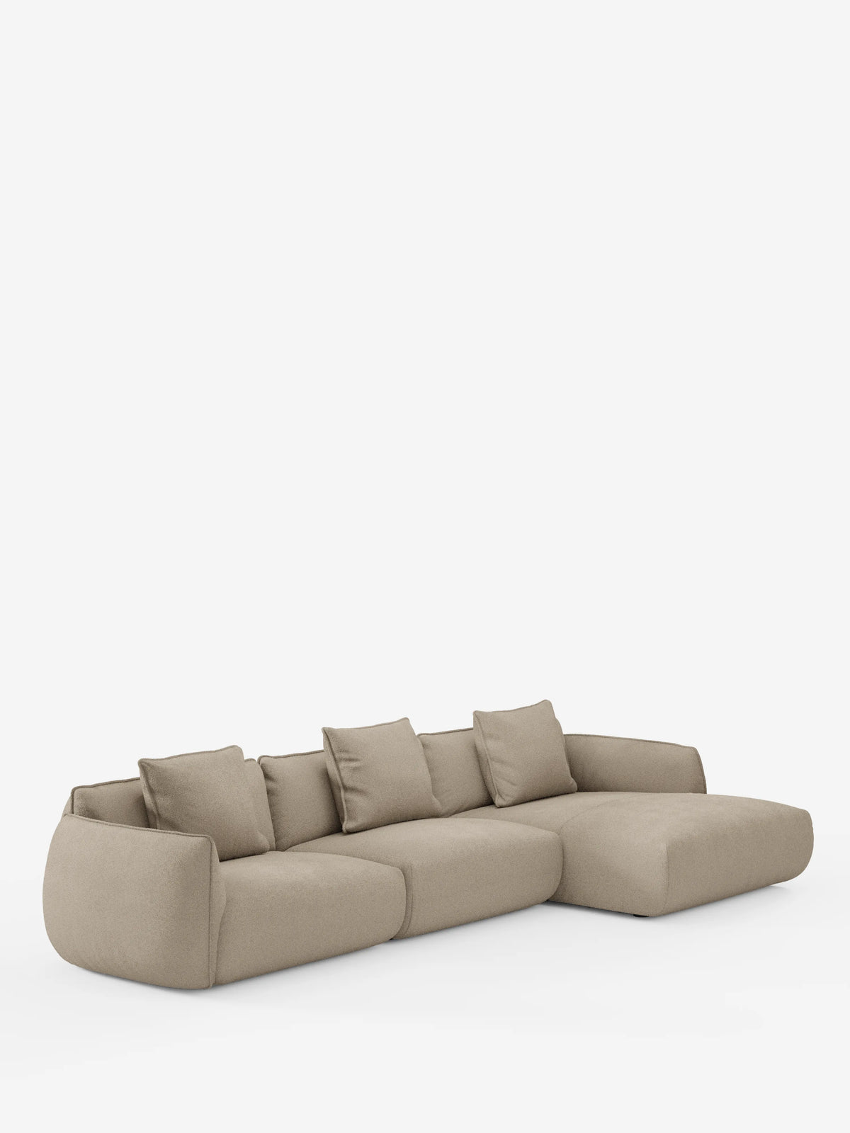 Un moderno divano angolare con penisola componibile Nimbus di divitt.sbs, rivestito in tessuto T33 effetto cotone beige chiaro, resistente alle macchie. Questo divano componibile presenta bordi morbidi e arrotondati e include cinque cuscini dello schienale sfoderabili. La sua chaise longue a forma di L si estende verso destra, mentre la struttura poggia direttamente sul pavimento senza gambe visibili, su uno sfondo bianco a tinta unita.