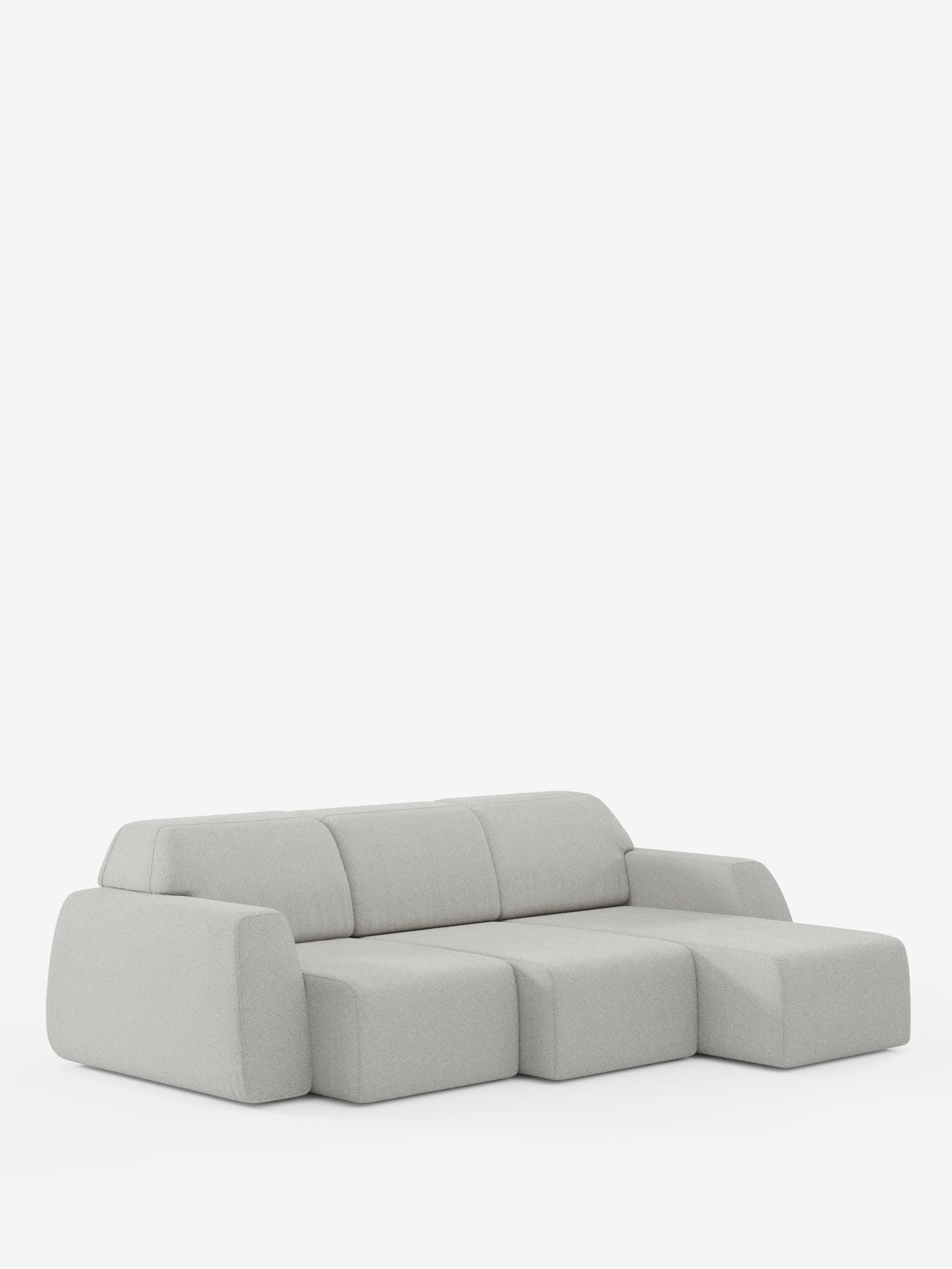 Il divano angolare Orbit di divitt.sbs è un divano componibile minimalista e moderno, di colore grigio chiaro, che spicca su uno sfondo bianco a tinta unita. Questo divano modulare presenta forme morbide e geometriche, con braccioli e schienale bassi e arrotondati, ed è dotato di una chaise longue reversibile e di sedute estensibili rivestite in tessuto T33 effetto cotone antimacchia. Non sono visibili altri elementi decorativi o mobili.