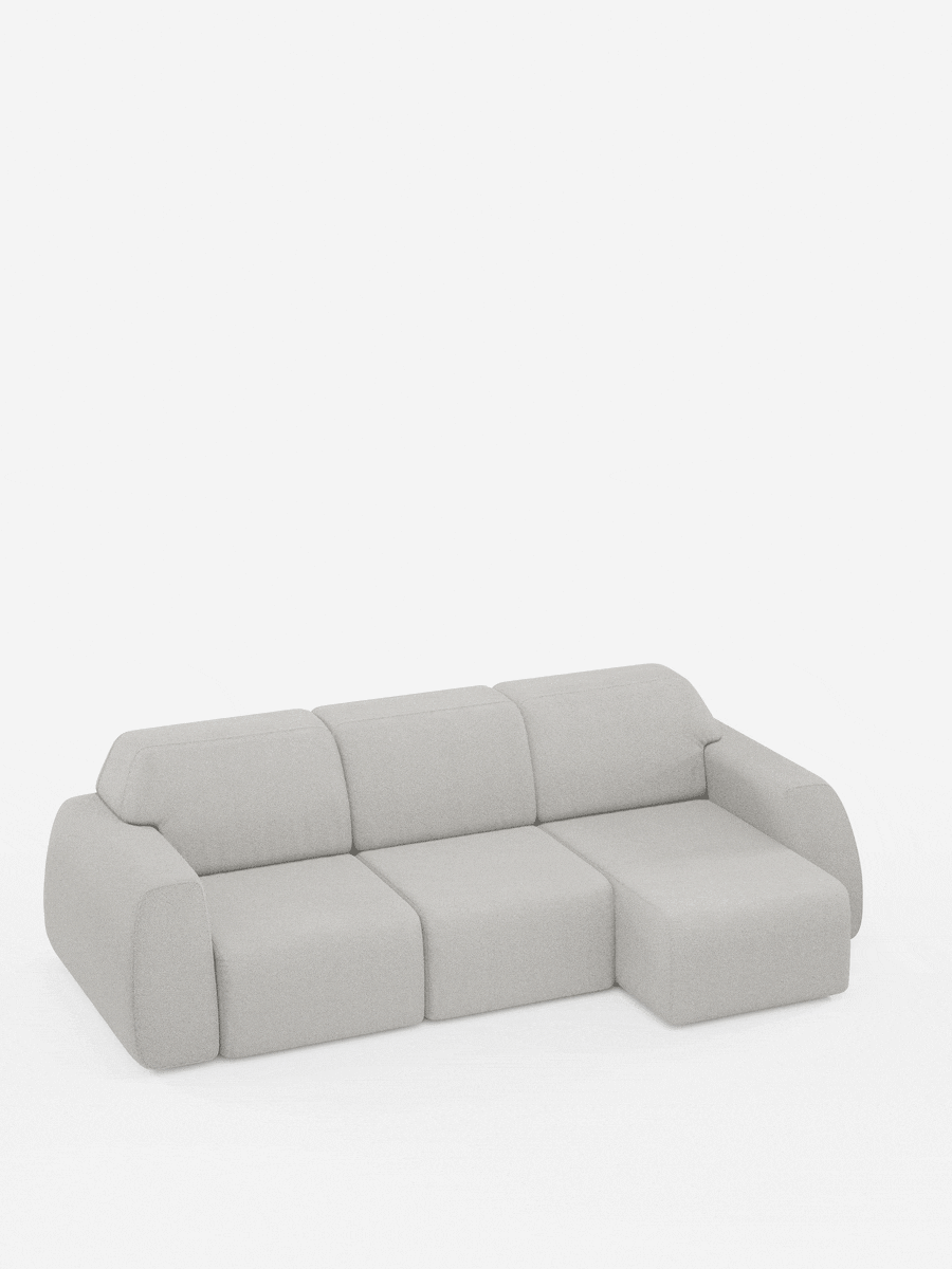 Un divano angolare Orbit contemporaneo, di colore grigio chiaro, con penisola reversibile e tutte le sedute allungabili, rivestito in tessuto smacchiabile effetto cotone T33 di divitt.sbs. Il modello presenta tre posti con chaise longue sul lato destro. Questo divano modulare si caratterizza per i braccioli arrotondati e il design minimalista, qui raffigurato su uno sfondo bianco a tinta unita.