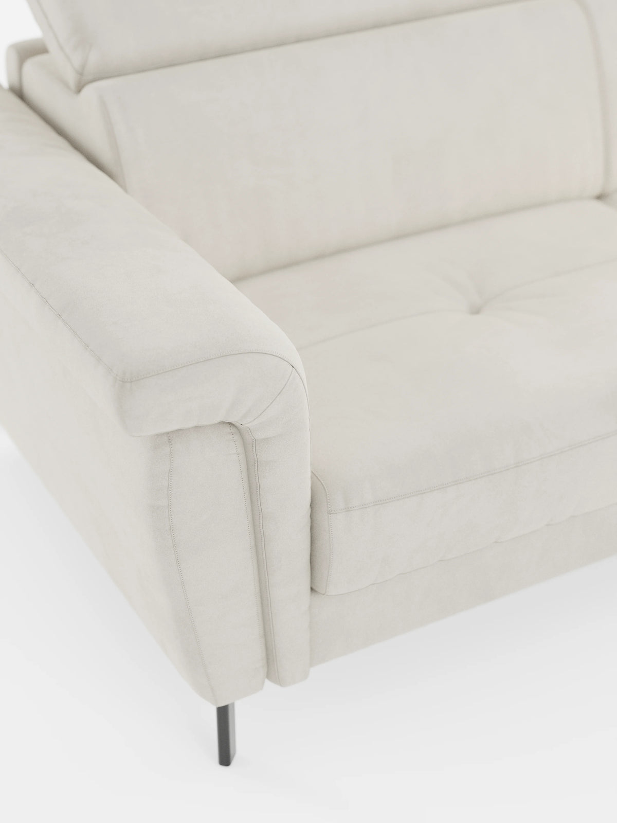 Primo piano del divano letto di design Capri con piedini alti di divitt.sbs, rivestito in raffinato tessuto T30 effetto velluto, resistente alle macchie. Caratterizzato da un bracciolo imbottito, un cuscino di seduta trapuntato, gambe alte in metallo nero e poggiatesta regolabili, questo moderno divano letto è esposto su uno sfondo bianco per mettere in risalto la morbida trama del tessuto effetto velluto e il suo design pulito e contemporaneo.