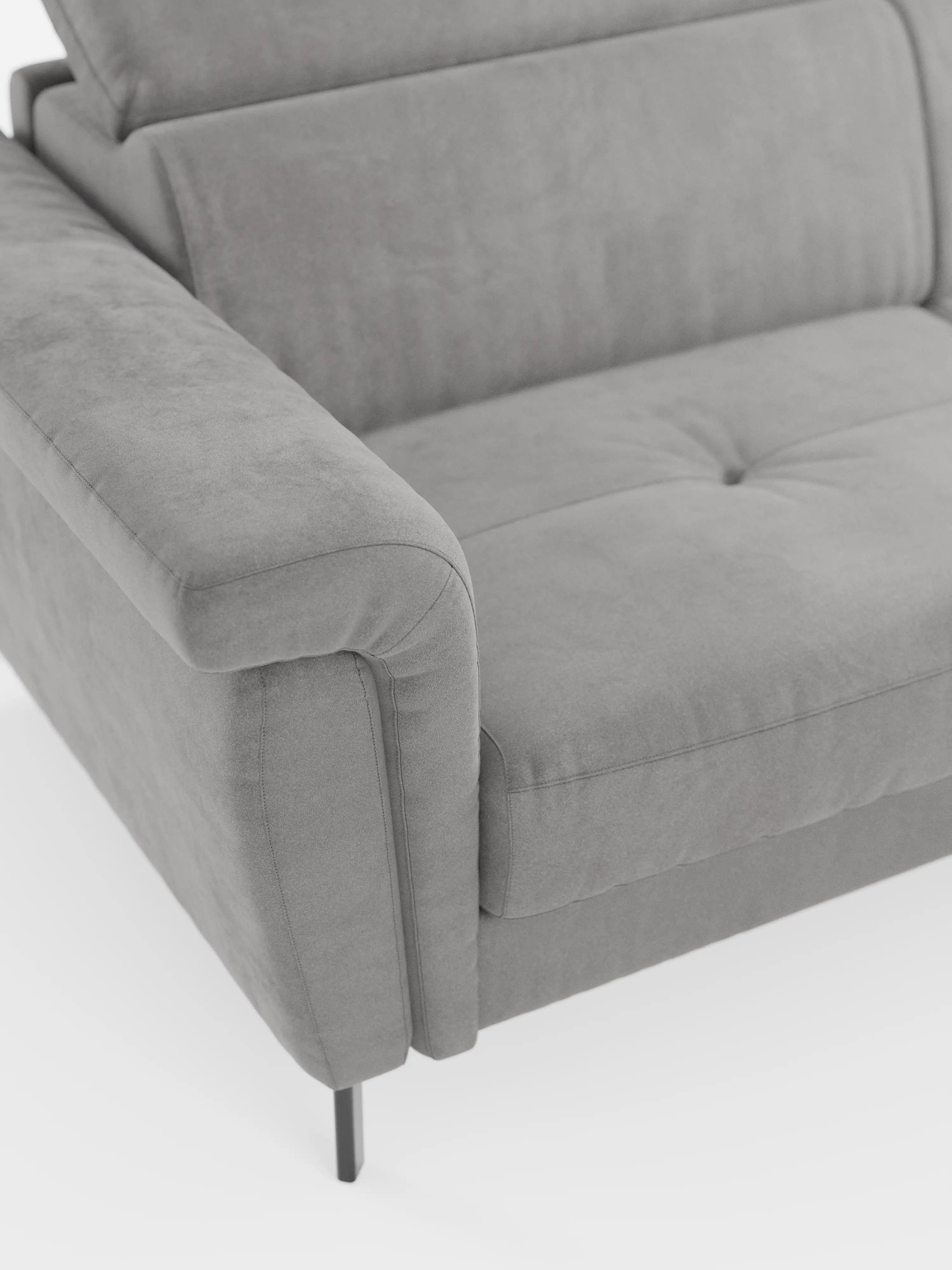 Un primo piano del divano letto di design Capri con piedini alti di divitt.sbs mette in risalto il suo elegante rivestimento in tessuto effetto velluto smacchiabile T30 in un moderno grigio, con seduta leggermente trapuntata, morbidi braccioli e slanciate gambe in metallo nero. Vista dall’alto su uno sfondo bianco, l’immagine mette in risalto il bracciolo sinistro e la zona di seduta, oltre alla raffinata manifattura italiana e ai poggiatesta reclinabili regolabili.