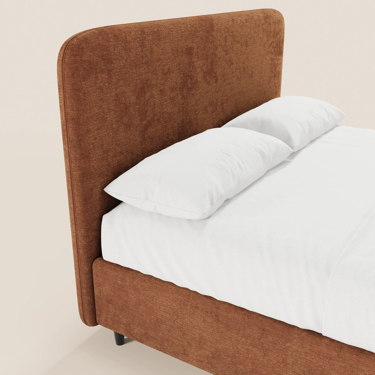 Un primo piano del letto KAELOS minimal imbottito di Letti.store, caratterizzato da una testiera alta e arrotondata in ciniglia, gambe alte e base contenitiva. Il letto è rifatto con cura, con lenzuola e cuscini bianchi su uno sfondo chiaro.