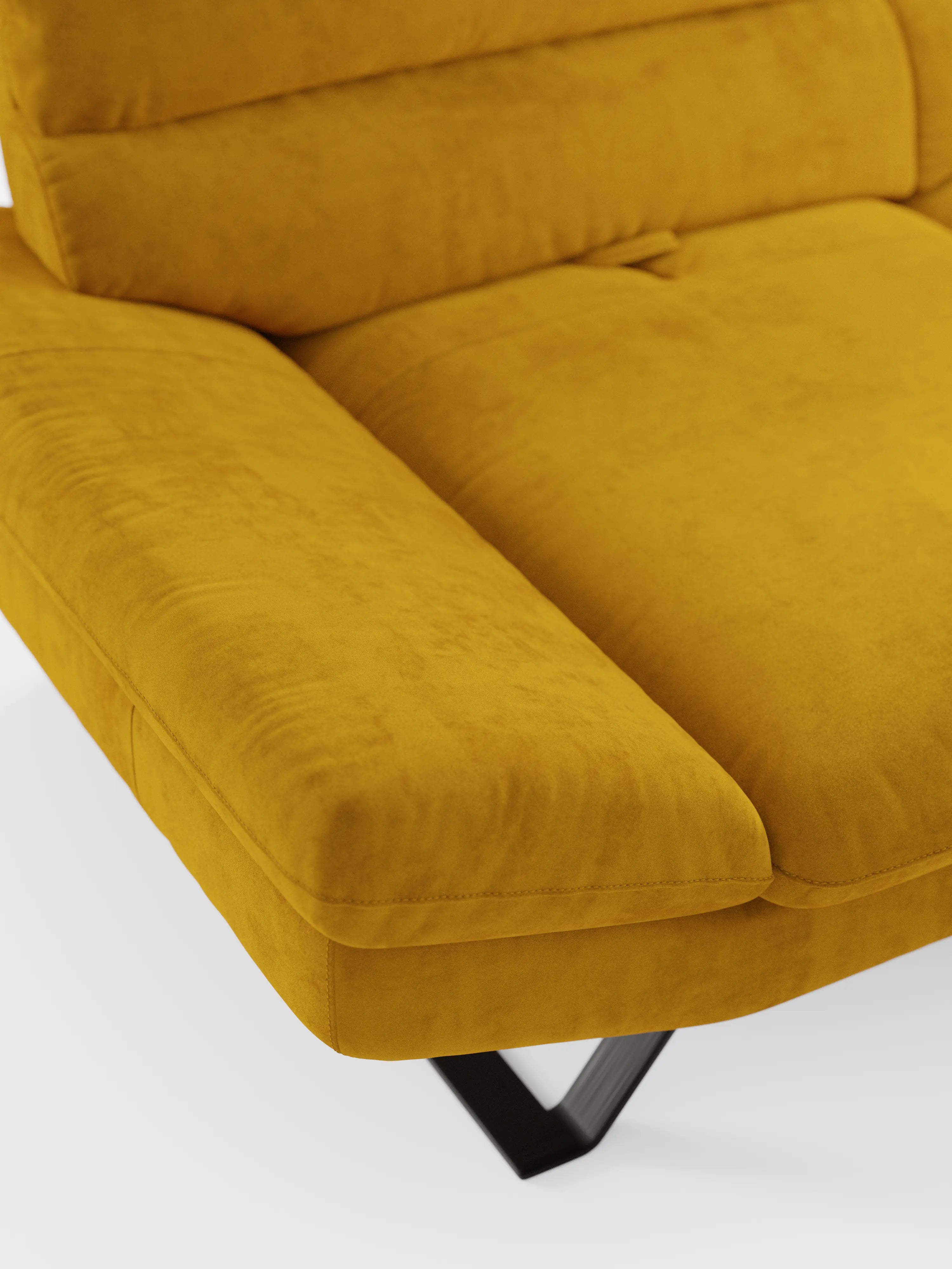 Primo piano del divano Eclipse dal design moderno a 2 e 3 posti di divitt.sbs, in una finitura contemporanea giallo senape, caratterizzato da morbidi cuscini e da eleganti gambe alte in metallo nero. Realizzato in elegante microfibra T11 resistente alle macchie, il tessuto appare morbido e vellutato, con una texture delicata che riflette lievi ombre lungo i suoi contorni. Gli schienali traslanti offrono una maggiore versatilità e un comfort modulabile, il tutto su uno sfondo bianco a tinta unita.