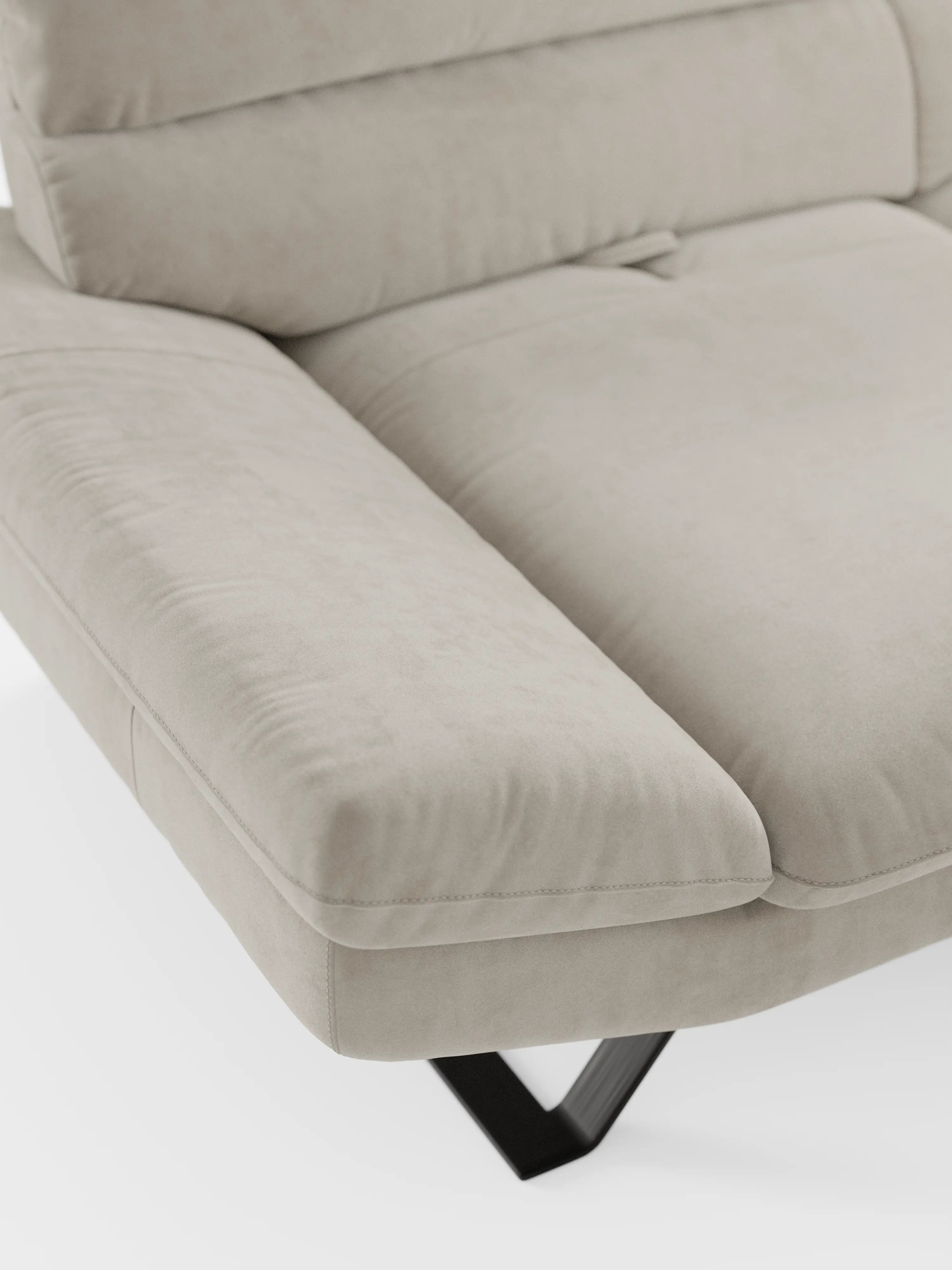Un primo piano dell’Eclipse Divano, dal design moderno, a 2 e 3 posti con schienali traslanti, di divitt.sbs, rivestito in elegante microfibra T11 beige chiaro resistente alle macchie. L’immagine mette in risalto i morbidi cuscini, i braccioli dal design moderno e una gamba angolata in metallo nero con piedini alti su uno sfondo bianco a tinta unita, evidenziando la morbida consistenza e il design contemporaneo del divano.