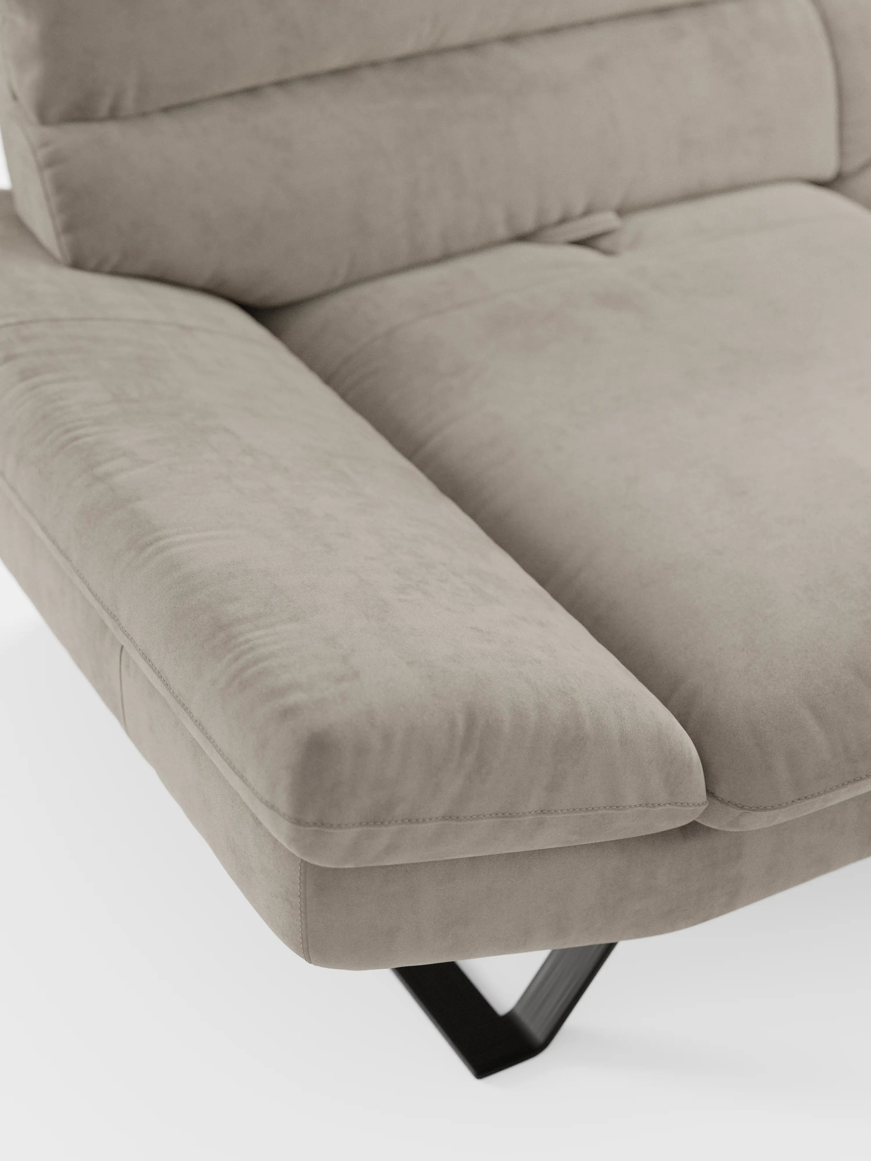 Primo piano del divano Eclipse dal design moderno di divitt.sbs, qui presentato come un raffinato divano angolare rivestito in elegante microfibra T11 smacchiabile, simile alla pelle scamosciata, color taupe. L'imbottitura morbida e gli ampi braccioli ne sottolineano lo stile contemporaneo, mentre le cuciture a vista e gli schienali traslanti offrono un comfort personalizzabile. I caratteristici piedini alti in metallo a forma di V di colore nero completano il look moderno sullo sfondo bianco.