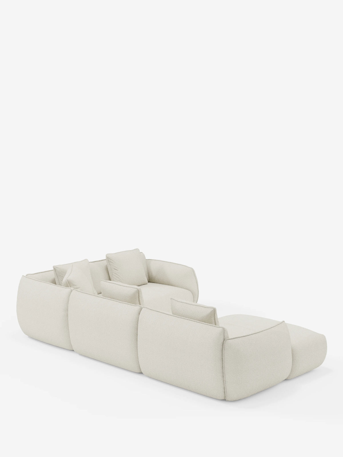 Un divano angolare panoramico modulare Nimbus, dal profilo basso e color beige, con penisola e angolo in tessuto smacchiabile T33 di divitt.sbs, Made in Italy, caratterizzato da tre ampie sezioni di seduta e cinque cuscini quadrati coordinati. Ritratto da un'angolazione posteriore su uno sfondo bianco a tinta unita, il suo design morbido e arrotondato conferisce a questo divano modulare un aspetto rilassato e contemporaneo.