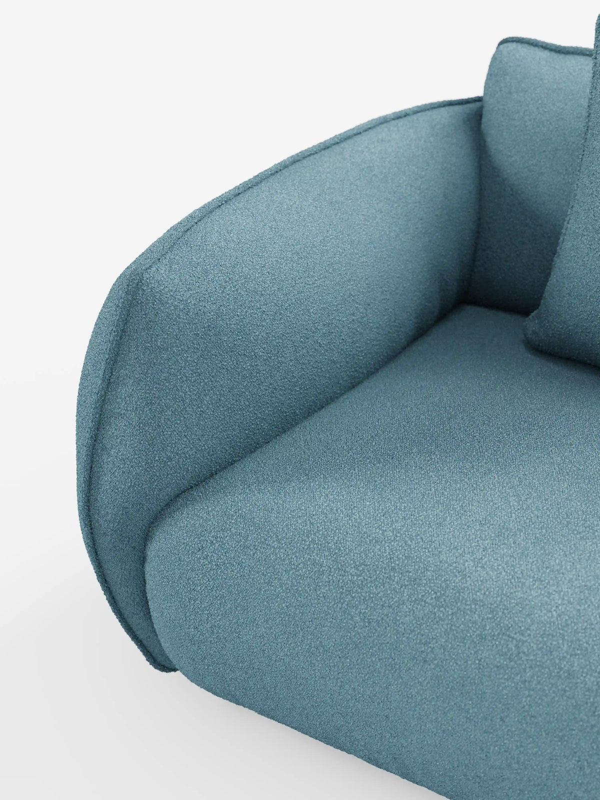 Primo piano del divano modulare e componibile Nimbus a 3 posti di divitt.sbs, lungo 250 cm e rivestito in tessuto sfoderabile e antimacchia effetto cotone t33 di colore blu. Il divano presenta un bracciolo arrotondato e un cuscino coordinato, con un rivestimento testurizzato che ne esalta le linee morbide e sinuose e l’imbottitura soffice. In primo piano su uno sfondo bianco a tinta unita.