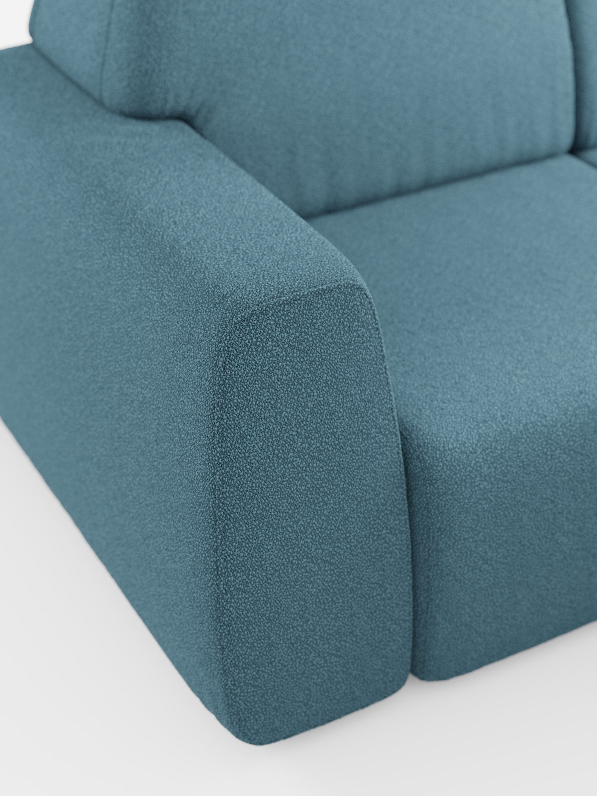 Primo piano del divano angolare Orbit con penisola reversibile e tutte le sedute allungabili di divitt.sbs, rivestito in tessuto T33 color verde acqua, effetto cotone e resistente alle macchie. L’immagine mette in risalto il bracciolo e parte del cuscino di seduta, evidenziandone le linee pulite e il rivestimento morbido e materico. Sullo sfondo bianco, la foto esalta il colore e il materiale distintivi di questo moderno divano componibile.