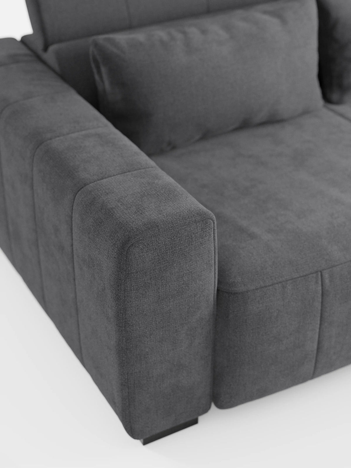 Un primo piano del divano angolare Doric con penisola e sedute allungabili con relax elettrico di divitt.sbs, rivestito in tessuto T23 grigio scuro, facile da pulire. Il divano presenta braccioli ampi e imbottiti e include un cuscino rettangolare abbinato sulla seduta, con morbida imbottitura e poggiatesta regolabili che evocano un comfort sofisticato e un design moderno. In primo piano su uno sfondo bianco a tinta unita.