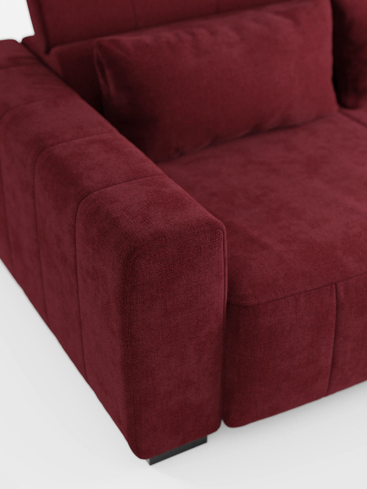 Primo piano del divano angolare Doric con penisola e sedute allungabili con funzione relax elettrica di divitt.sbs, presentato in tessuto T23 rosso intenso smacchiabile. L’immagine mette in risalto il bracciolo sinistro, il cuscino di seduta e un cuscino dello schienale abbinato, evidenziandone la morbida trama che ne esalta il comfort lussuoso. Con i poggiatesta reclinabili e i piedini neri bassi, questo divano moderno si staglia con eleganza su uno sfondo bianco.