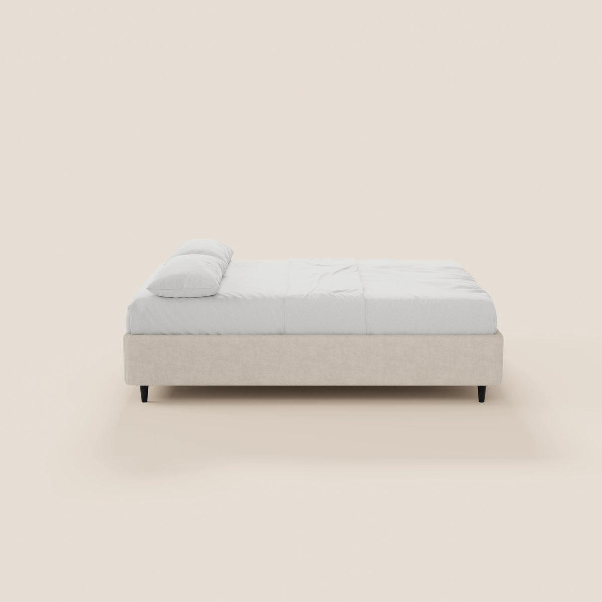 Il letto sommier imbottito ERON di Letti.store presenta una struttura in tessuto beige impermeabile certificato Oeko-Tex, biancheria da letto bianca, un cuscino singolo, gambe corte scure e un design moderno e minimalista, raffigurato di profilo su uno sfondo beige chiaro.