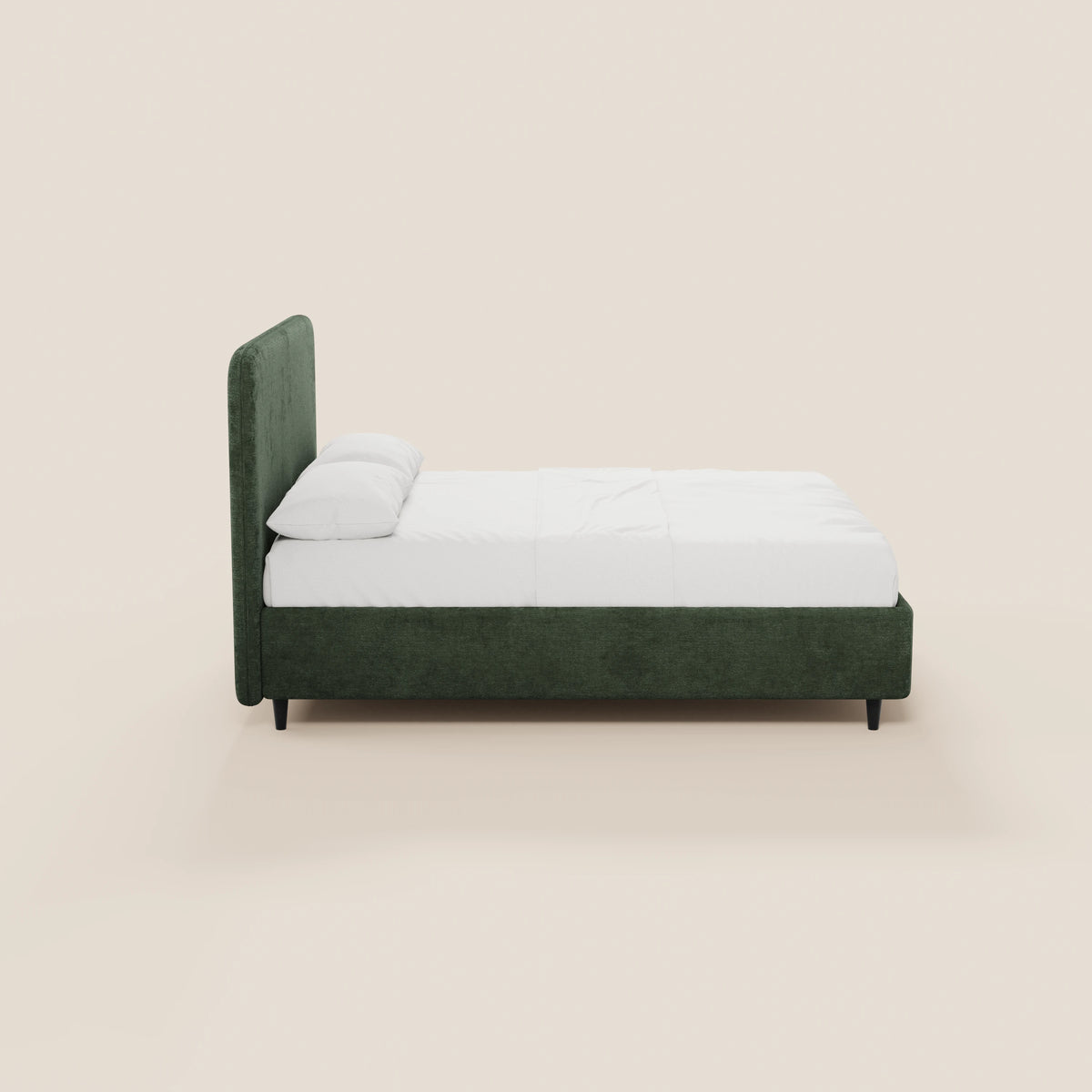Vista laterale del letto KAELOS minimal imbottito di Letti.store, caratterizzato da una struttura rivestita in ciniglia verde scuro con testiera alta e arrotondata, gambe alte nere, biancheria da letto bianca e due cuscini bianchi su uno sfondo beige chiaro.