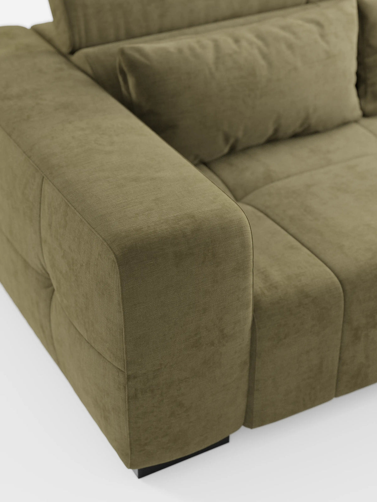 Primo piano del divano Monarch con funzione relax elettrica per l’allungamento delle sedute e poggiatesta reclinabile di divitt.sbs, rivestito in morbido tessuto T31 antimacchia in una tonalità verde-oliva. L'immagine mette in risalto il bracciolo, il cuscino della seduta, il cuscino dello schienale e parte dello schienale stesso, esaltandone le linee semplici e moderne e il rivestimento testurizzato su uno sfondo bianco.
