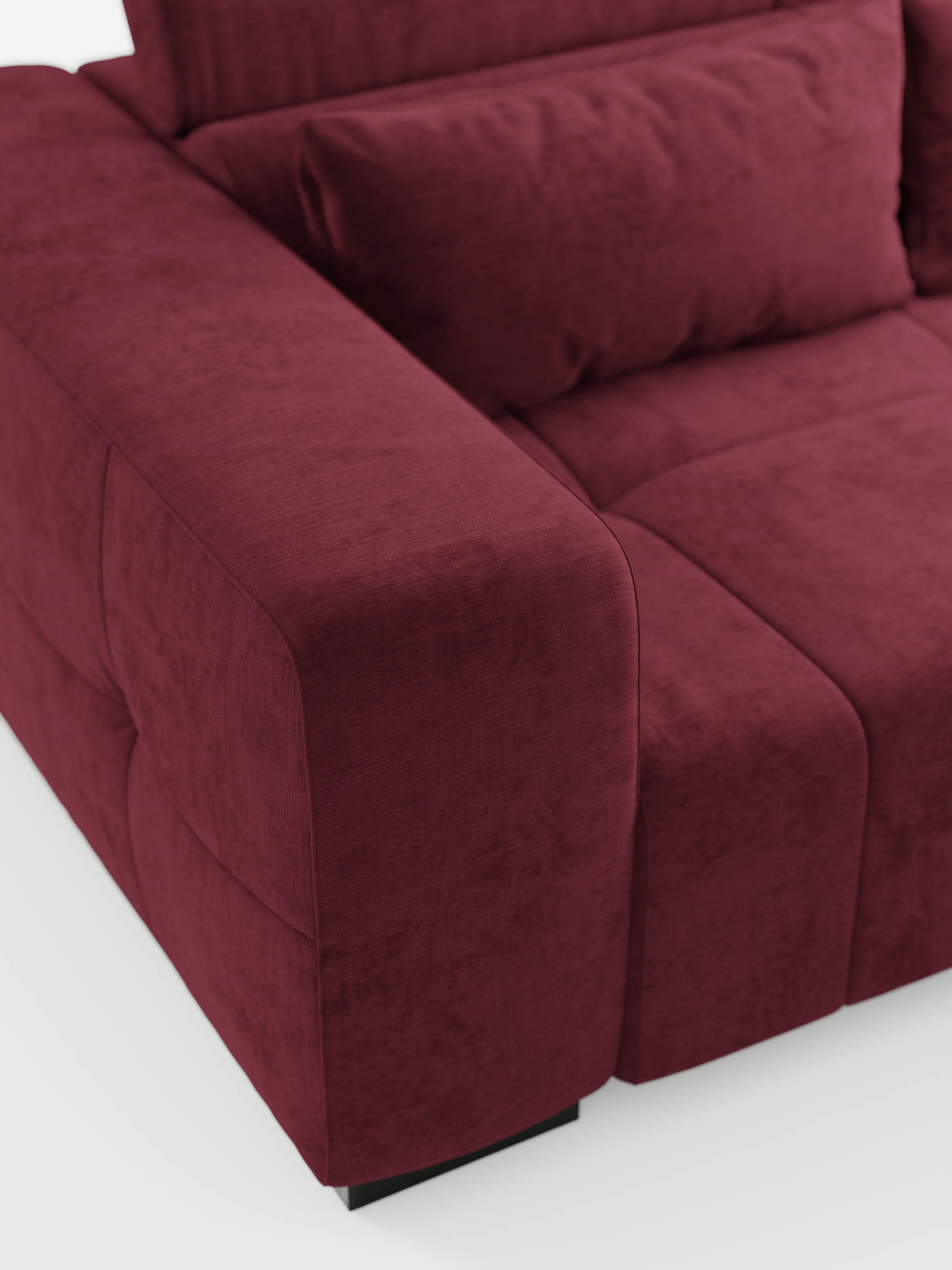 Un primo piano del divano Monarch con funzione relax elettrica per l’allungamento delle sedute e poggiatesta reclinabile, realizzato in morbido tessuto lavabile T31 di divitt.sbs. L'immagine mette in risalto l'ampio e morbido bracciolo, la seduta trapuntata e un cuscino dello schienale abbinato. Dotato di un poggiatesta reclinabile per un comfort ancora maggiore, questo moderno divano rosso intenso poggia su brevi gambe nere su uno sfondo bianco, creando un look pulito ed elegante.