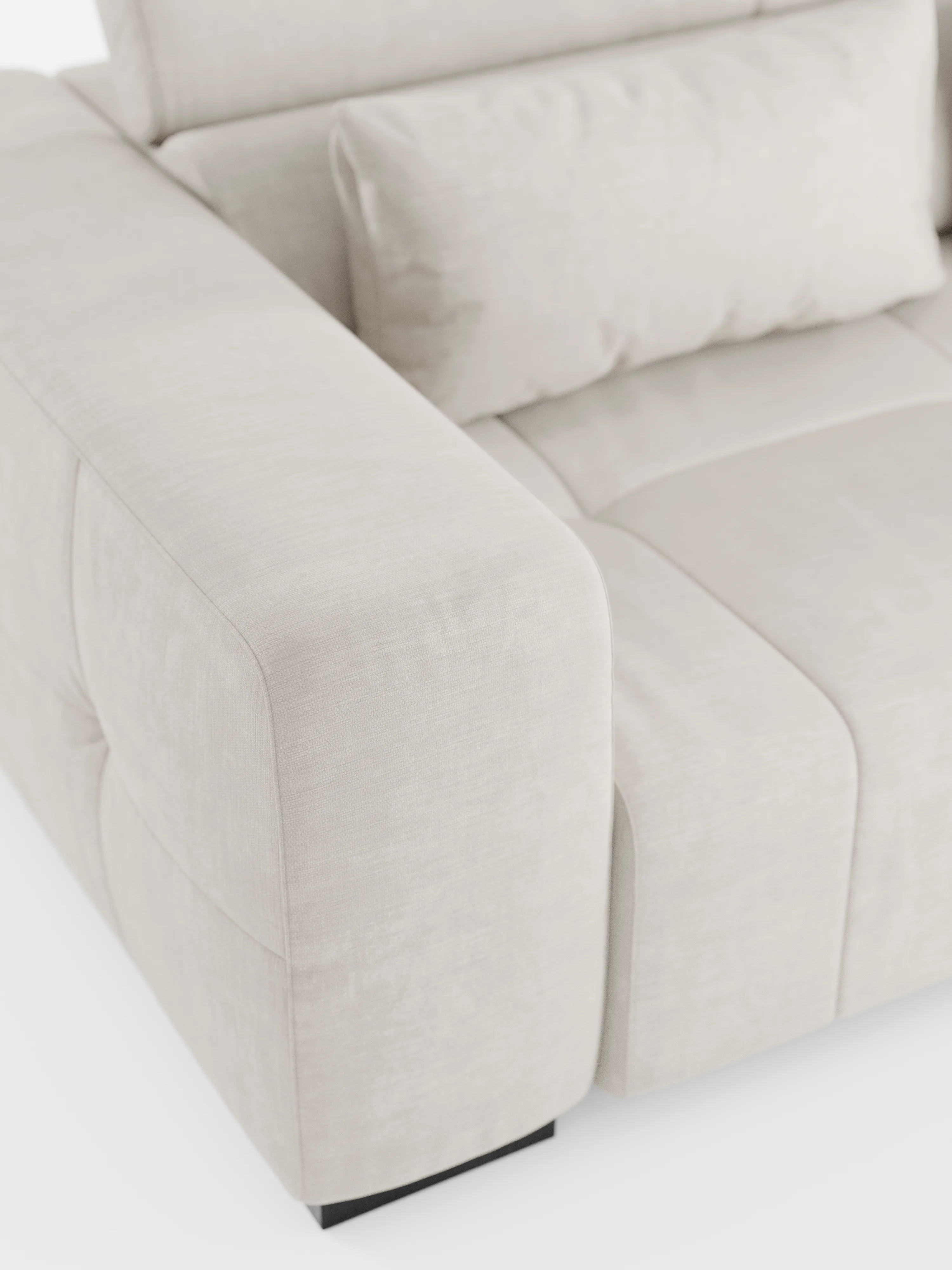 Primo piano del divano angolare Monarch con penisola e sistema Relax elettrico per l’allungamento delle sedute di divitt.sbs, rivestito in morbido tessuto T31 resistente alle macchie. Questo moderno divano color beige chiaro presenta ampi braccioli imbottiti, morbidi cuscini dello schienale con cuciture a vista e poggiatesta regolabili. Ispirato al design italiano dei divani relax elettrici, poggia su gambe corte di colore scuro e si distingue per la sua texture accogliente e il fascino contemporaneo.