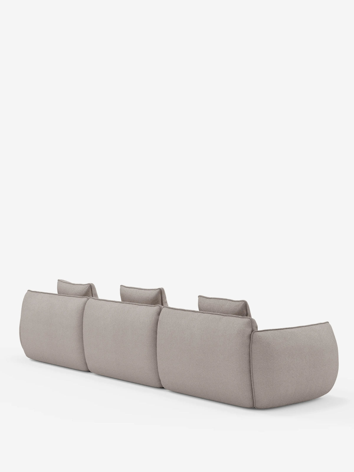 Un divano angolare modulare Nimbus in grigio chiaro, dal design minimalista, di divitt.sbs, è raffigurato di spalle su uno sfondo bianco a tinta unita. Il divano presenta tre ampie sedute modulari rivestite in morbido tessuto T33 effetto cotone, resistente alle macchie, con schienali bassi, bordi arrotondati e delicati dettagli di cucitura.