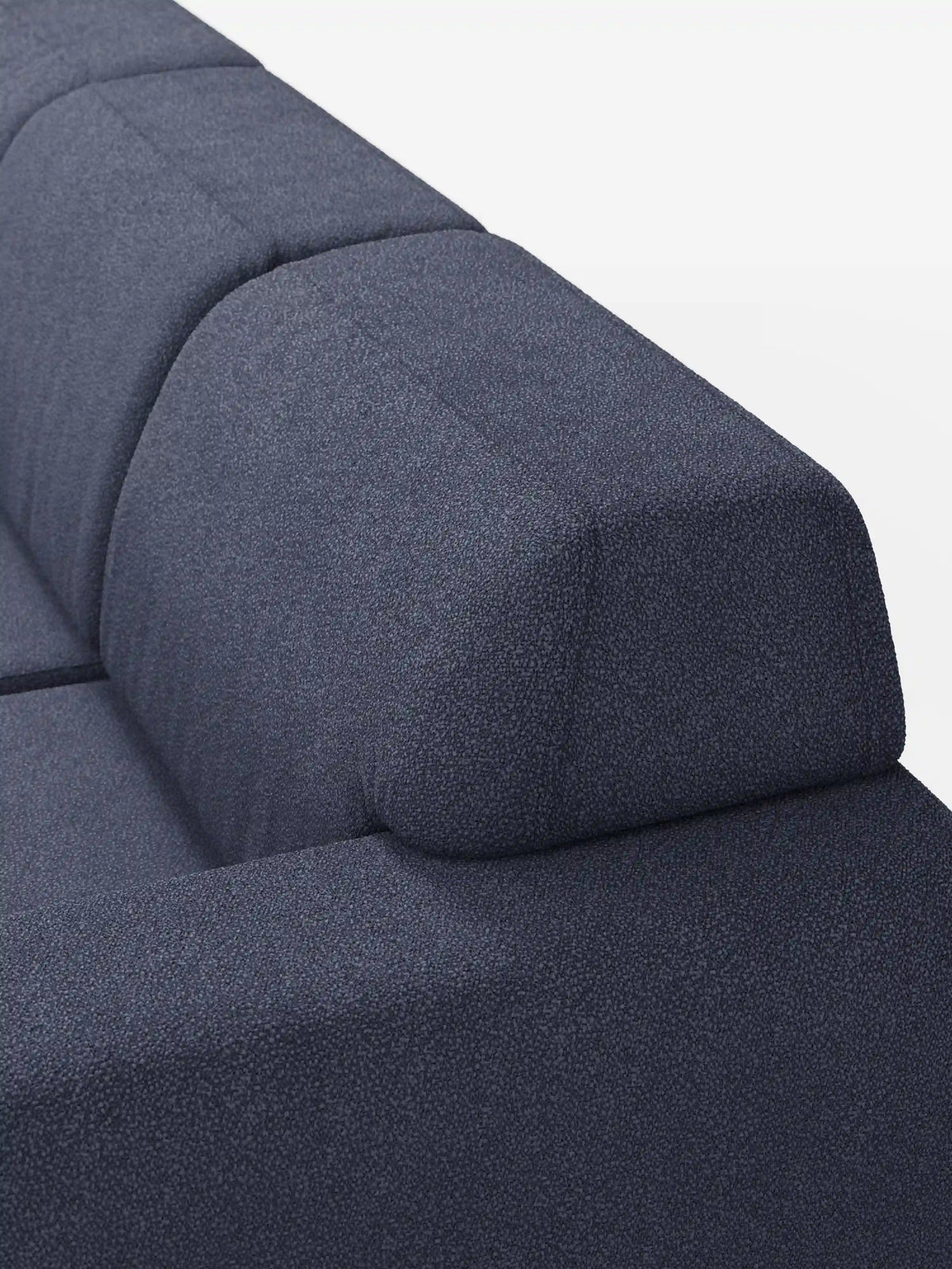Primo piano del divano Orbit con 3 sedute scorrevoli e allungabili di divitt.sbs, rivestito in tessuto effetto cotone smacchiabile T33 di colore blu intenso. L’immagine mette in risalto la superficie testurizzata, con particolare attenzione al bracciolo e allo schienale. Il divano presenta linee pulite e moderne, sedute scorrevoli indipendenti e uno schienale imbottito per un maggiore comfort. È completamente sfoderabile per una facile manutenzione, mentre la sua ricca tonalità di blu risalta sullo