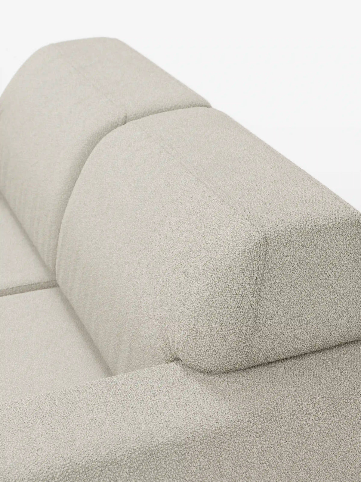 Primo piano del divano a due posti Orbit di divitt.sbs, rivestito in tessuto T33 beige chiaro, resistente alle macchie e con una trama effetto cotone. L’immagine mette in risalto i cuscini della parte superiore e dello schienale del divano, caratterizzati da linee pulite, imbottitura rigida e rivestimenti facilmente sfoderabili. Su uno sfondo bianco a tinta unita, la foto ne esalta il design moderno e l’eleganza sobria.