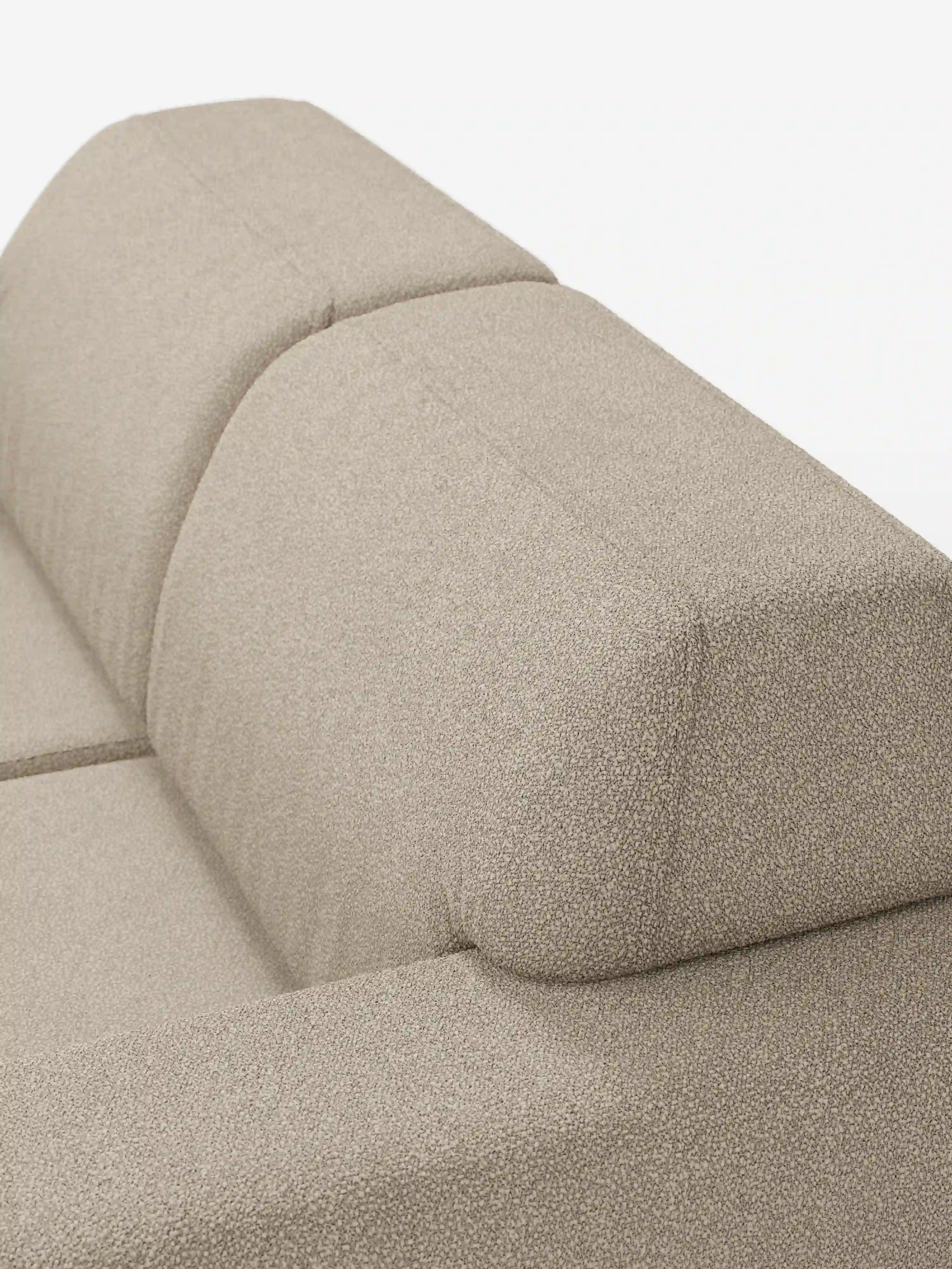 Primo piano del divano Orbit a 2 e 3 posti con sedute scorrevoli di divitt.sbs, rivestito in tessuto smacchiabile beige effetto cotone T33. La parte superiore dello schienale e i braccioli sono mostrati in dettaglio, con un delicato motivo screziato e cuciture a vista che accentuano i contorni e la morbidezza dei cuscini. Questo divano moderno completamente sfoderabile è un esempio di design contemporaneo e risalta su uno sfondo bianco a tinta unita.