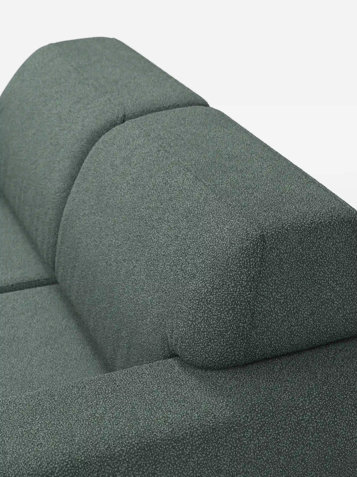 Primo piano del divano Orbit a 2 e 3 posti con sedute scorrevoli di divitt.sbs, rivestito con il tessuto smacchiabile T33 verde testurizzato effetto cotone. L’immagine mette in risalto il suo design pulito e geometrico, caratterizzato da linee rette, uno schienale inclinato e cuciture a vista, su uno sfondo bianco a tinta unita. Completamente sfoderabile e ideale per interni contemporanei.