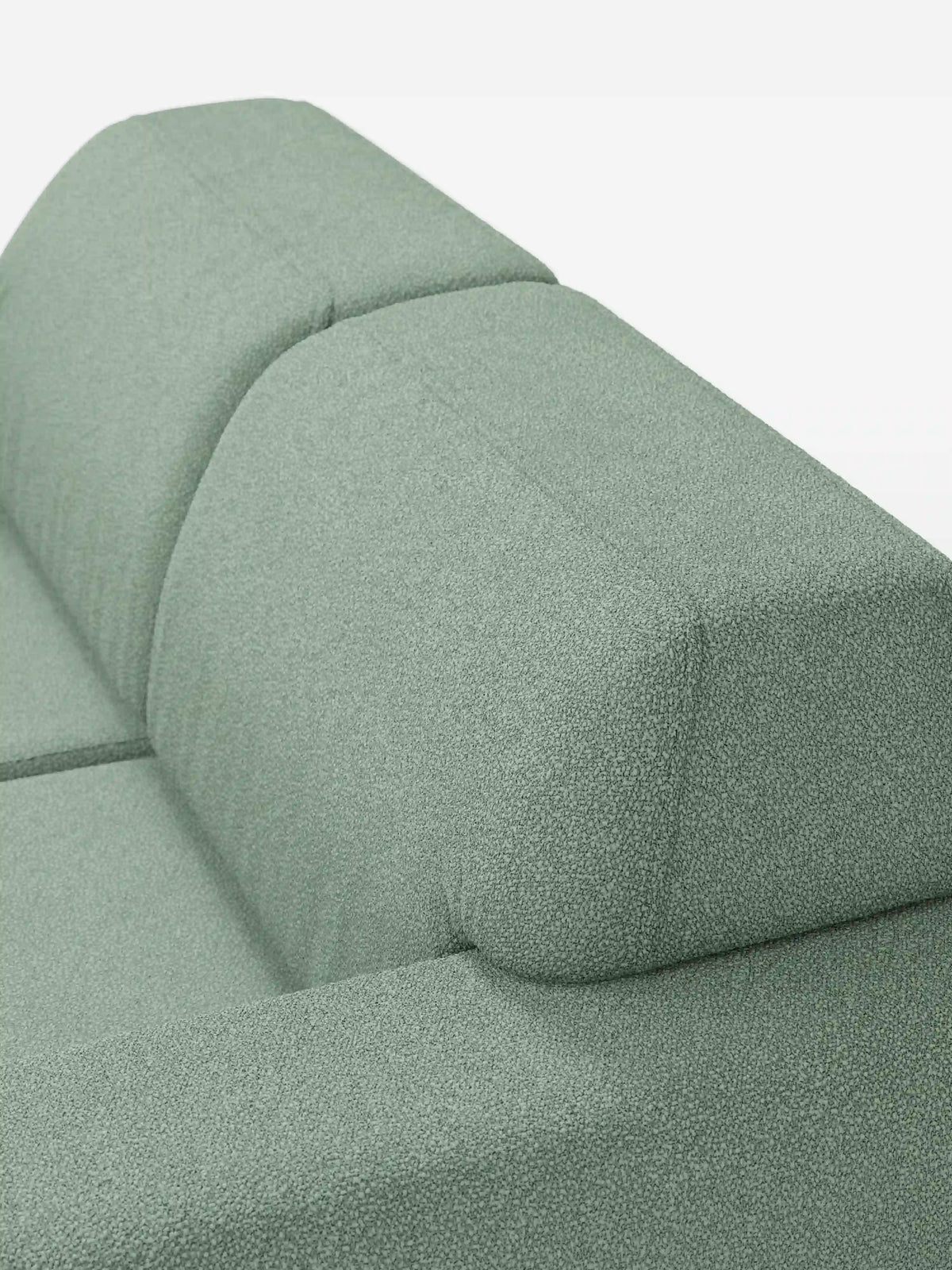 Primo piano del divano Orbit a 2 e 3 posti con sedute scorrevoli di divitt.sbs, rivestito in tessuto T33 verde salvia effetto cotone, resistente alle macchie. Questo divano moderno è dotato di rivestimenti completamente sfoderabili e si caratterizza per un rivestimento morbido e soffice dalle linee semplici e pulite. Su uno sfondo bianco, il colore del divano e la trama del tessuto sono i veri protagonisti.