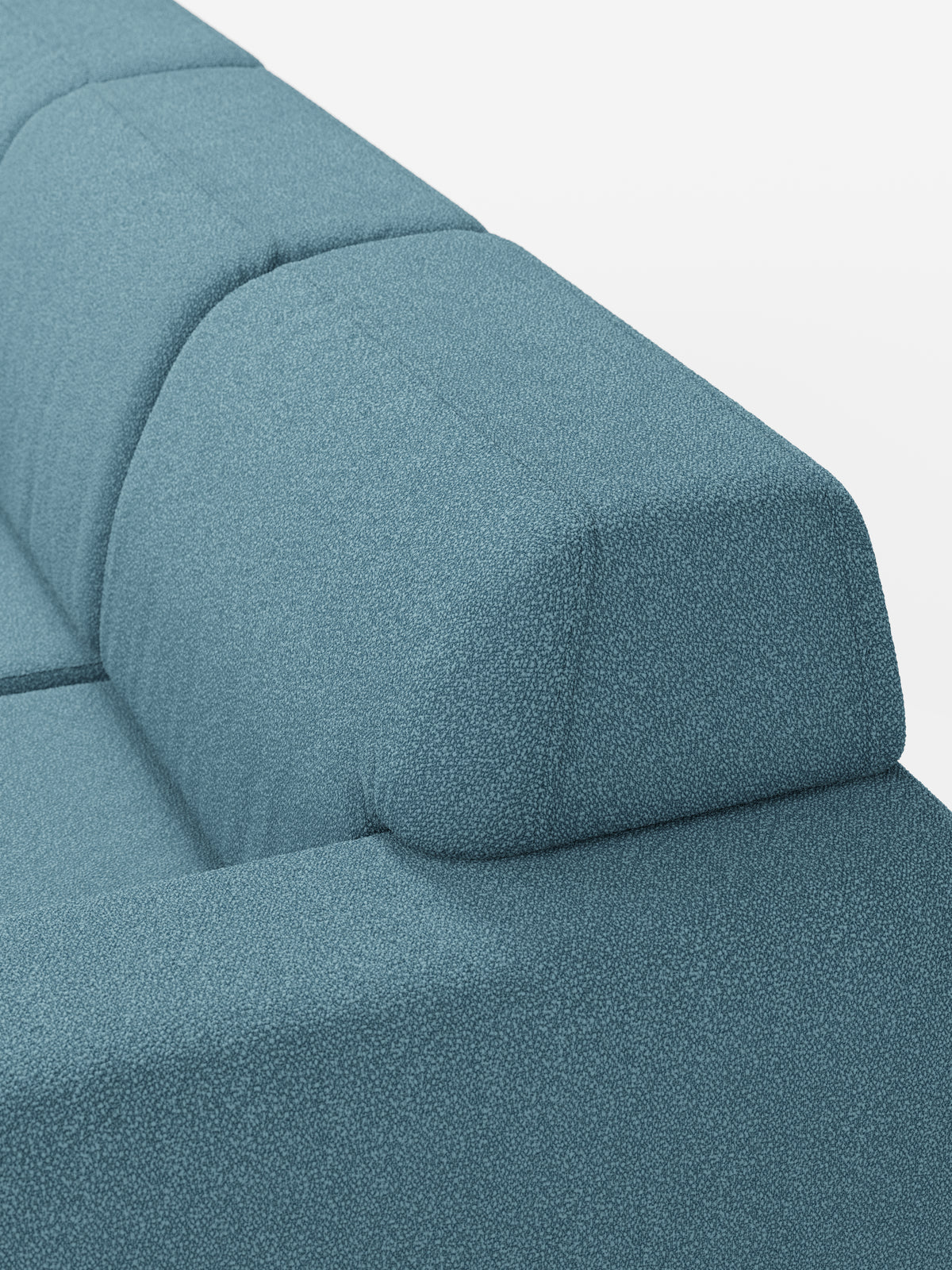 Primo piano del divano angolare Orbit con penisola reversibile e tutte le sedute allungabili di divitt.sbs, rivestito in tessuto smacchiabile effetto cotone T33 in una moderna tonalità di blu. La foto mette in risalto le cuciture pulite sullo schienale e sui braccioli, nonché il design semplice e spigoloso del divano. Sullo sfondo bianco a tinta unita, l’immagine sottolinea sia la forma versatile che il colore vivace di questo elemento modulare.