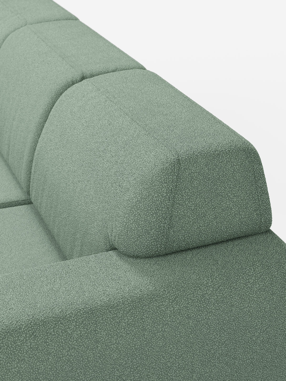 Primo piano del divano angolare Orbit con penisola reversibile e tutte le sedute allungabili di divitt.sbs, rivestito in tessuto T33 verde chiaro antimacchia con una trama effetto cotone. L’immagine mette in risalto le linee pulite e le forme geometriche dello schienale e dei cuscini, sottolineando il design contemporaneo del divano su uno sfondo bianco a tinta unita.