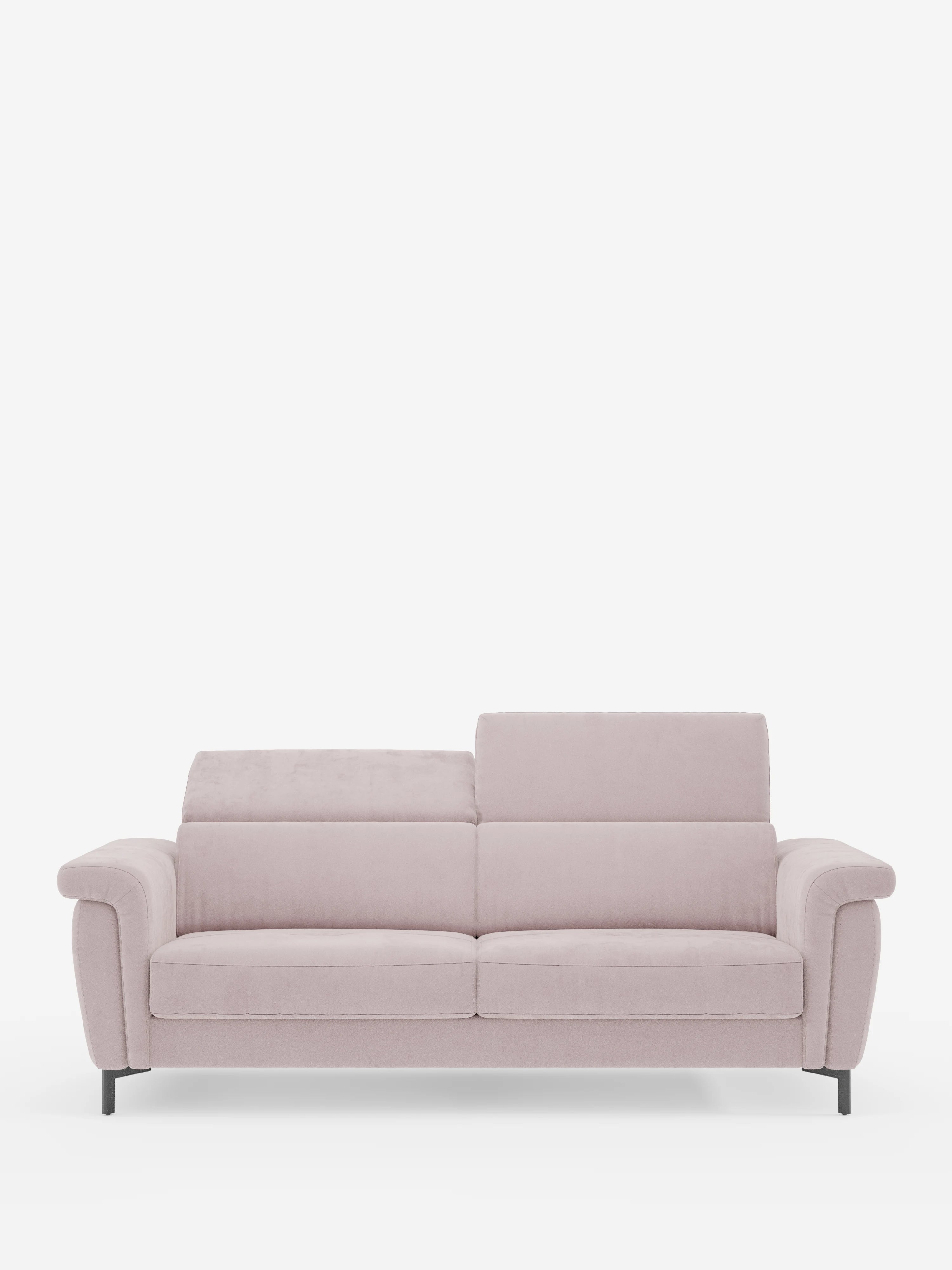 Un divano letto Capri a due posti in rosa chiaro, dal design contemporaneo, firmato divitt.sbs, caratterizzato da gambe alte e slanciate di colore nero, morbidi cuscini e poggiatesta reclinabili rivestiti in raffinato tessuto T30 effetto velluto, facile da pulire, è posizionato al centro su uno sfondo bianco a tinta unita. Il poggiatesta sinistro è regolato in modo da risultare leggermente più basso rispetto a quello destro, creando un effetto asimmetrico.