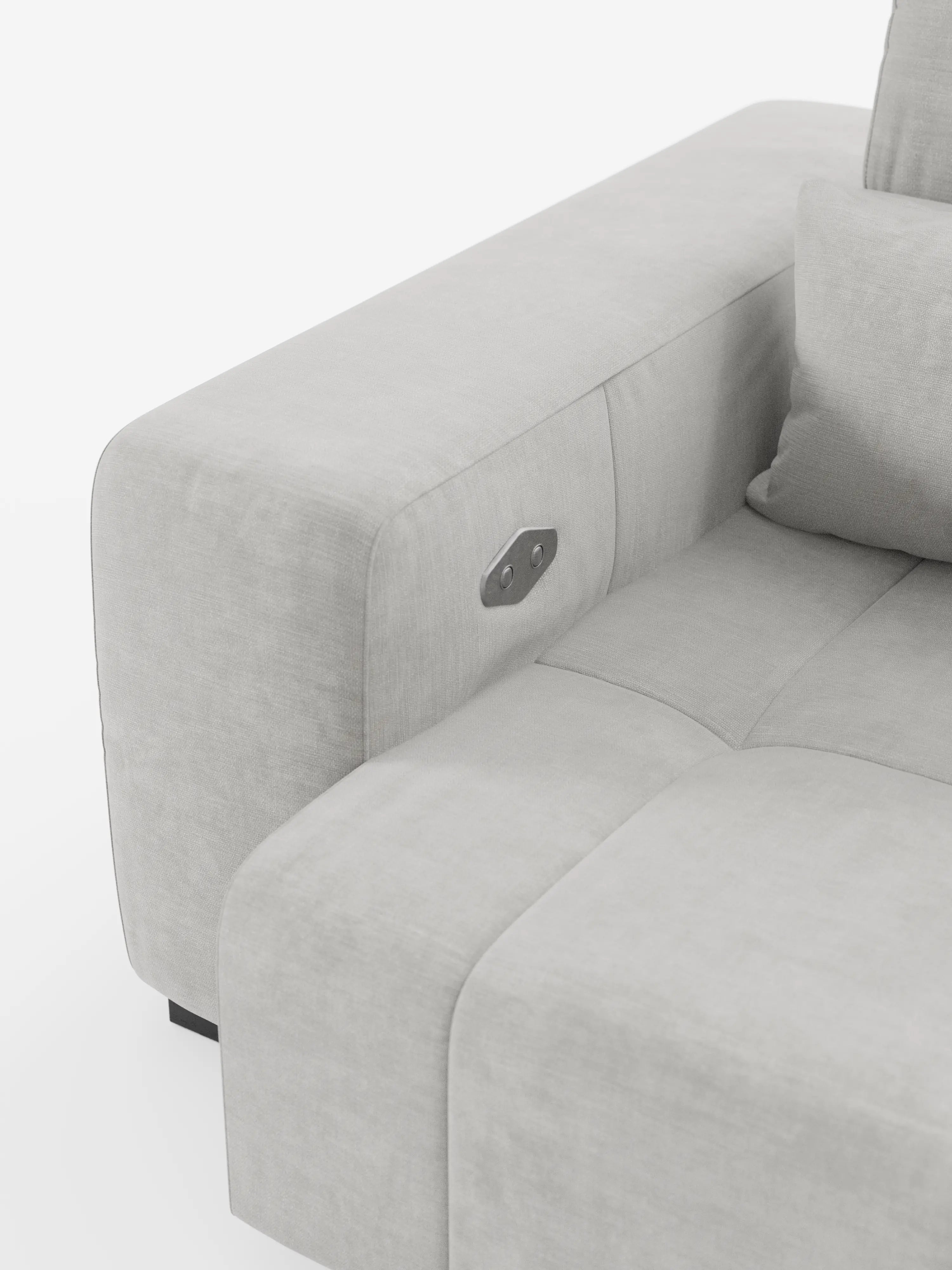 Primo piano del divano Monarch con funzione relax elettrica per l’allungamento delle sedute e poggiatesta reclinabile, rivestito in morbido tessuto antimacchia T31 di divitt.sbs. Questo elegante divano è dotato di ampi braccioli, cuscini dello schienale e un pannello di controllo integrato con pulsanti comodamente posizionati sul lato interno del bracciolo. Il design minimalista si caratterizza per il rivestimento morbido e antimacchia e le linee pulite.