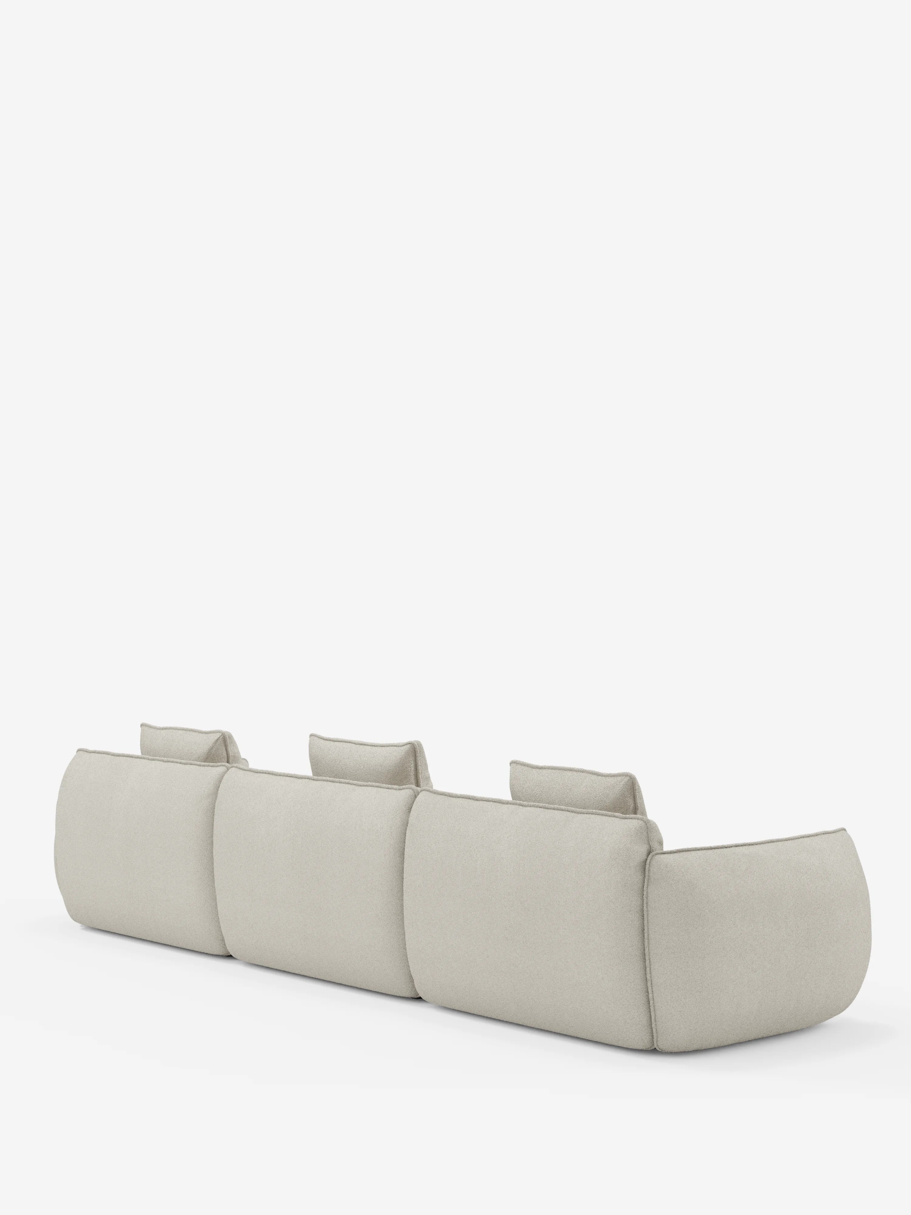 Un divano modulare beige “Nimbus a 3 posti componibile in morbido tessuto smacchiabile effetto cotone T33” di divitt.sbs è raffigurato di spalle su uno sfondo bianco. Questo divano sfoderabile presenta ampi braccioli arrotondati e tre poggiatesta regolabili singolarmente, il tutto in un design minimalista e moderno.