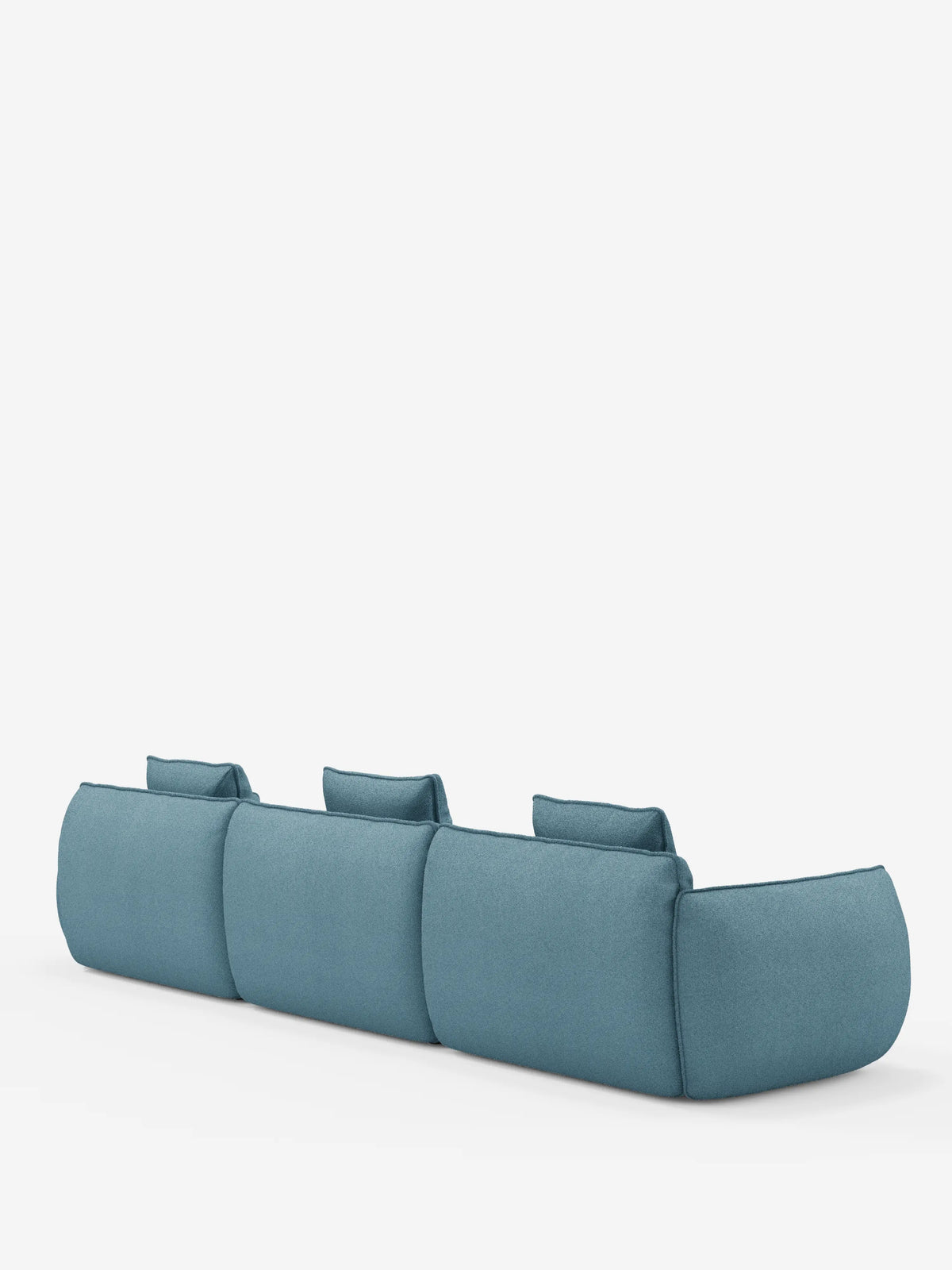 Vi presentiamo il divano modulare a 3 posti Nimbus, realizzabile in morbido tessuto smacchiabile effetto cotone T33 di divitt.sbs: un moderno divano componibile blu caratterizzato da tre ampie sedute e cuscini dello schienale rettangolari, ripreso di retro su uno sfondo bianco a tinta unita. Questo divano componibile presenta bordi morbidi e arrotondati che ne definiscono l’estetica minimalista e contemporanea.