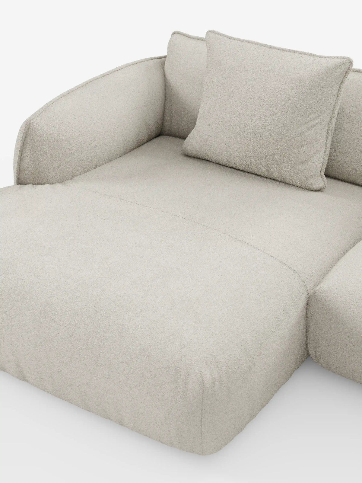 Un divano angolare panoramico componibile moderno e minimalista, di colore beige, con penisola e angolo: il modello Nimbus di divitt.sbs, è esposto su uno sfondo bianco. Realizzato in Italia, questo elegante divano presenta braccioli ricurvi, un unico cuscino quadrato abbinato e un morbido tessuto T33 smacchiabile dalla trama soffice, che gli conferisce un aspetto lussuoso e confortevole.