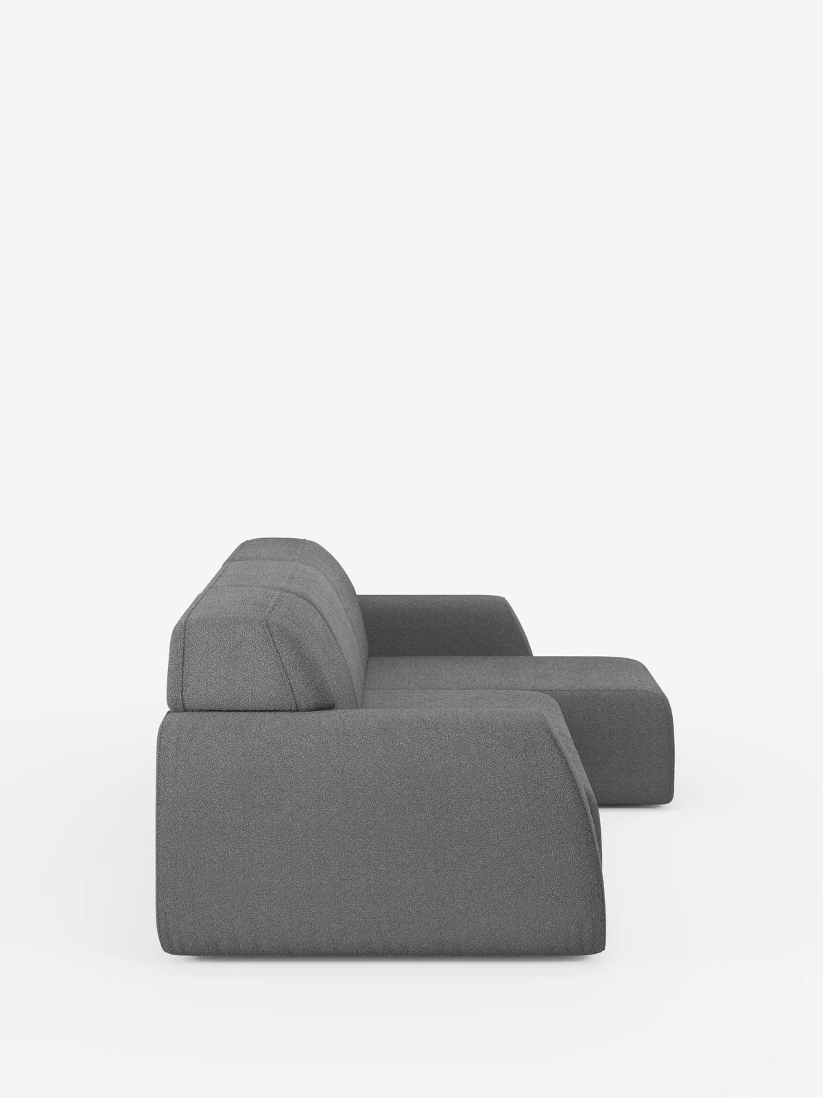 Un divano componibile grigio, elegante e moderno: l’Orbit Divano angolare con penisola reversibile e tutte le sedute allungabili in tessuto smacchiabile effetto cotone T33 di divitt.sbs è raffigurato di profilo. Questo divano modulare vanta linee pulite, una silhouette slanciata e un unico bracciolo destro, il tutto su uno sfondo bianco a tinta unita: un connubio perfetto tra versatilità ed eleganza contemporanea.