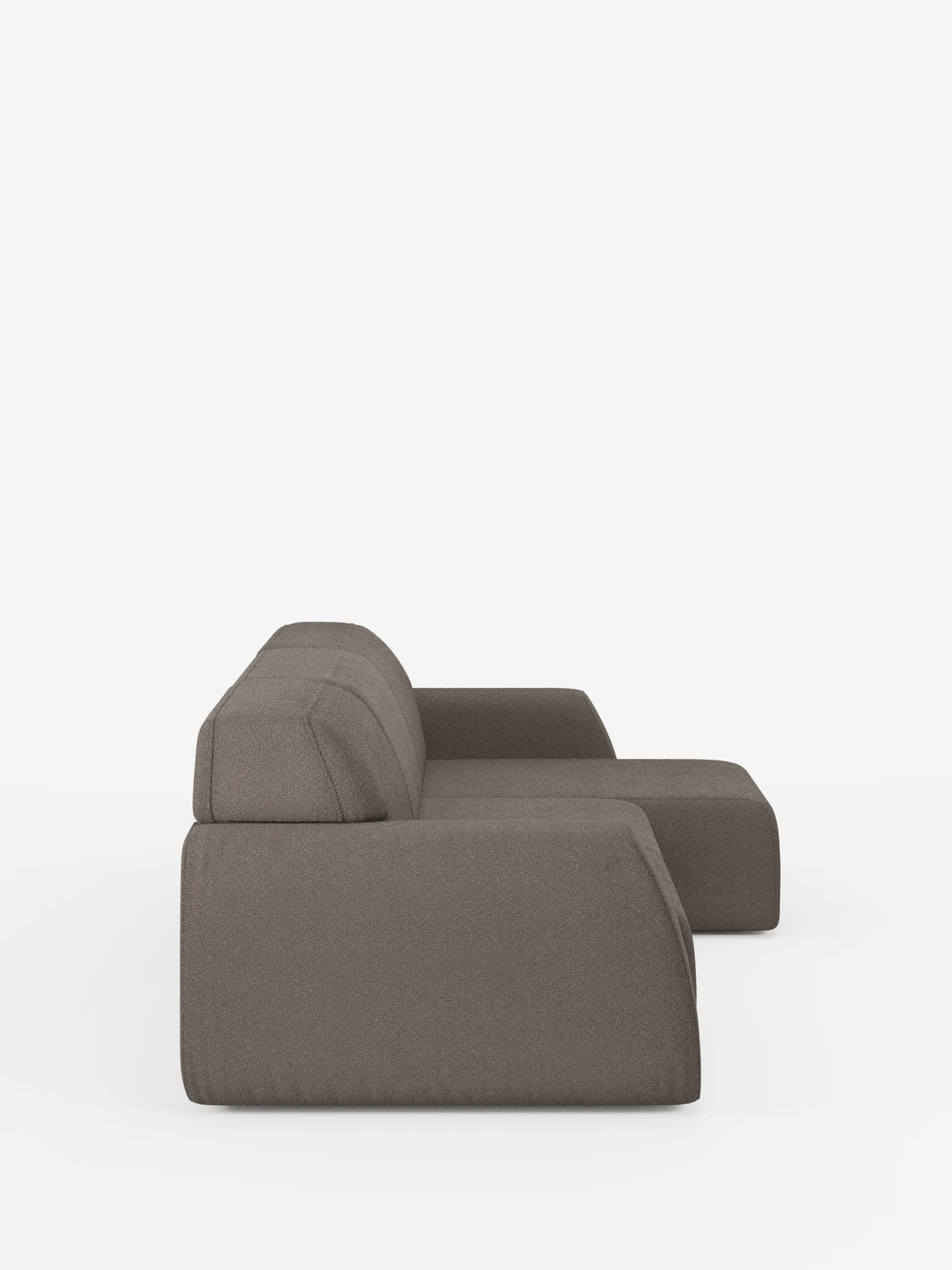 Vista laterale del divano angolare Orbit con penisola reversibile e tutte le sedute allungabili di divitt.sbs, che ne mette in risalto il design elegante e squadrato. Il divano è rivestito in tessuto T33 smacchiabile effetto cotone marrone e presenta uno schienale basso con cuscini di seduta profondi. Sullo sfondo bianco a tinta unita, lo stile minimalista e contemporaneo di questo divano di alta gamma risulta ancora più accentuato.