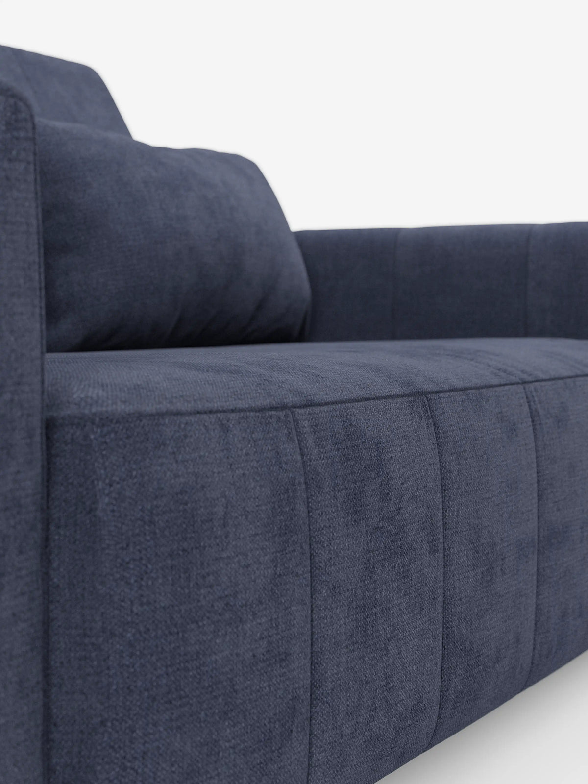 Primo piano del divano dorico a 3 posti di divitt.sbs, rivestito in tessuto T23 blu navy smacchiabile con cuciture a vista e finitura testurizzata. Caratterizzato da linee dritte e squadrate, braccioli alti e un cuscino coordinato, questo divano moderno è dotato di sedute estensibili azionate da una funzione relax elettrica e di un poggiatesta reclinabile. Immagine su sfondo bianco.