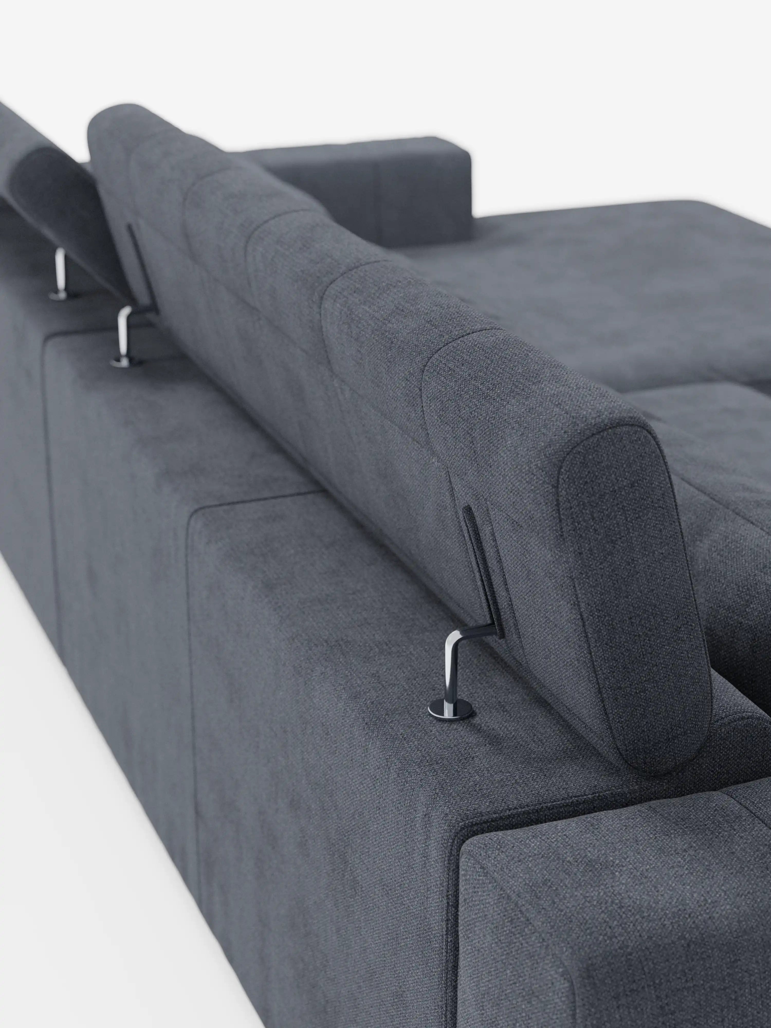 Un divano angolare in stile dorico contemporaneo con penisola e sedute allungabili con funzione relax elettrica di divitt.sbs è ripreso da dietro in una prospettiva obliqua. Rivestito in tessuto T23 grigio scuro e resistente alle macchie, questo divano moderno presenta morbidi cuscini, poggiatesta reclinabili regolabili, eleganti supporti in metallo e un design minimalista, ideale per interni contemporanei. Lo sfondo è bianco a tinta unita.